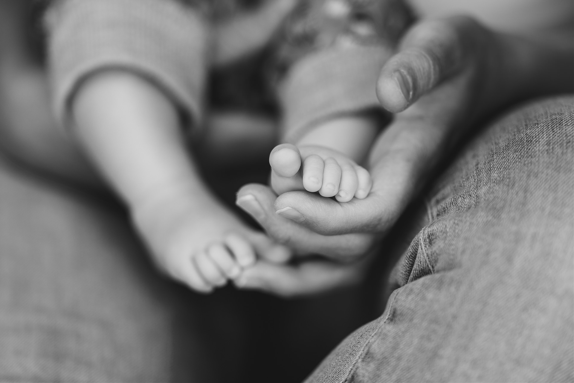 Devon baby photography image of a woman's hand holding tiny baby feet