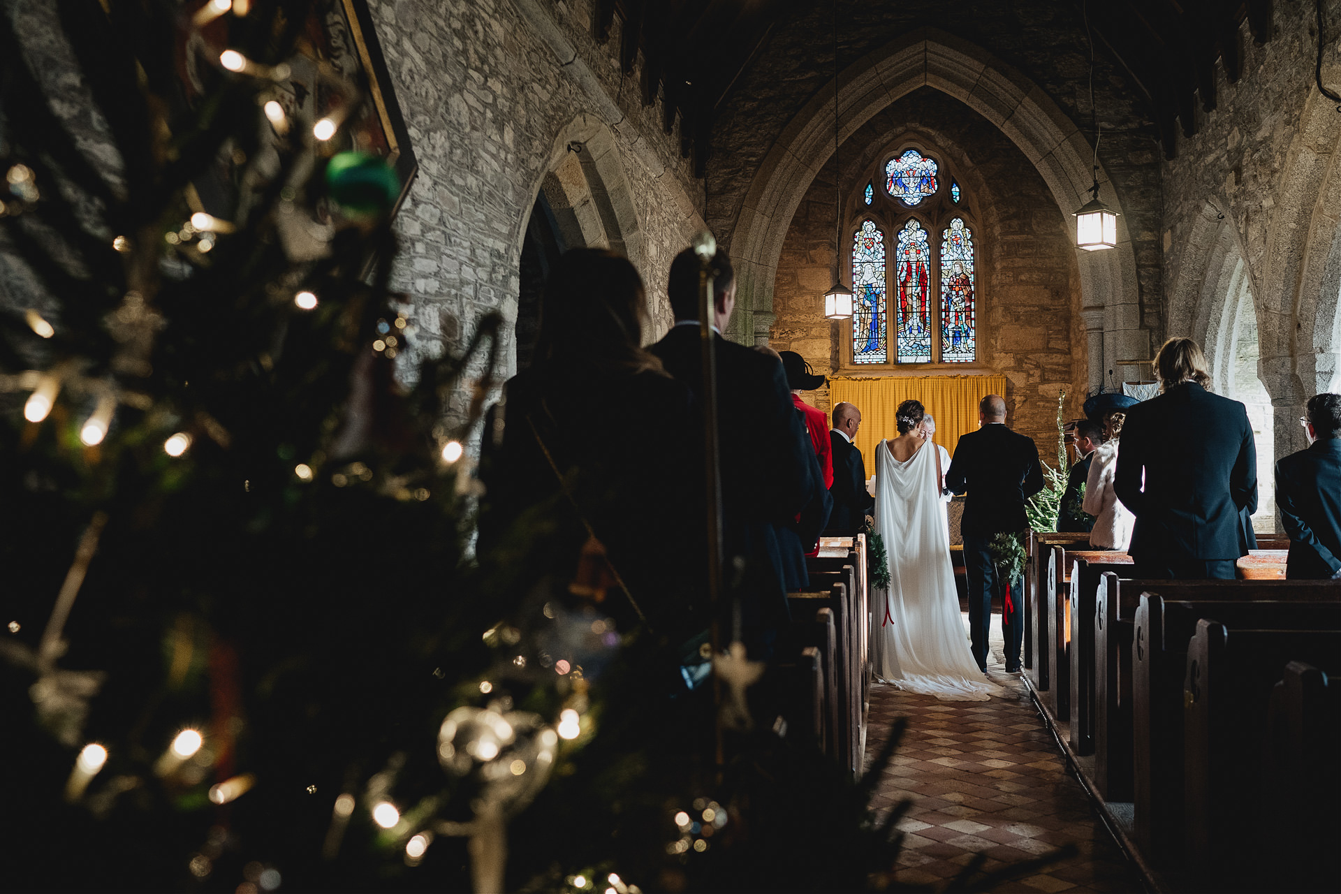 Bride and groom in a church with a Christmas tree