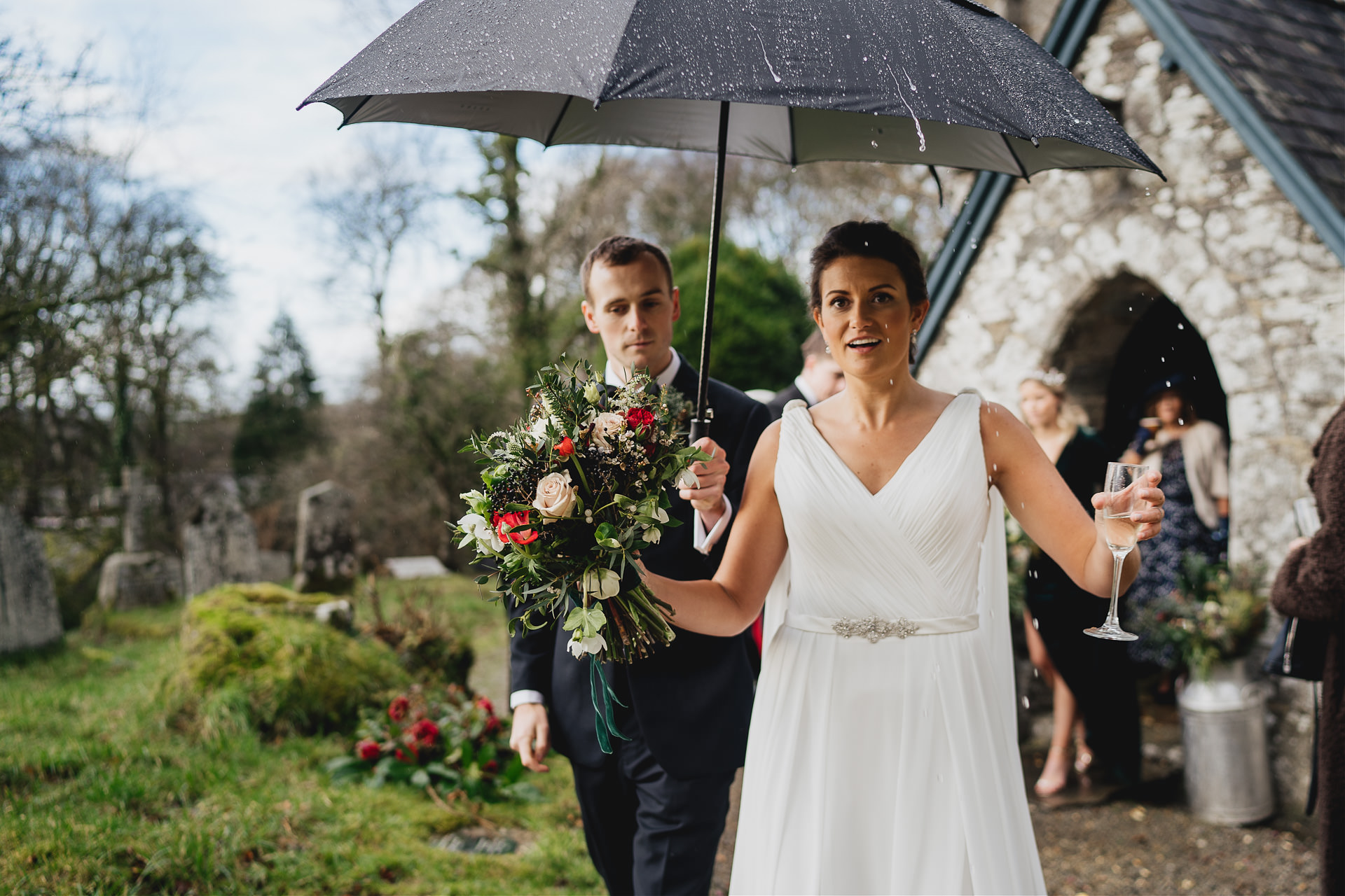 A bride under an umbrella in the rain