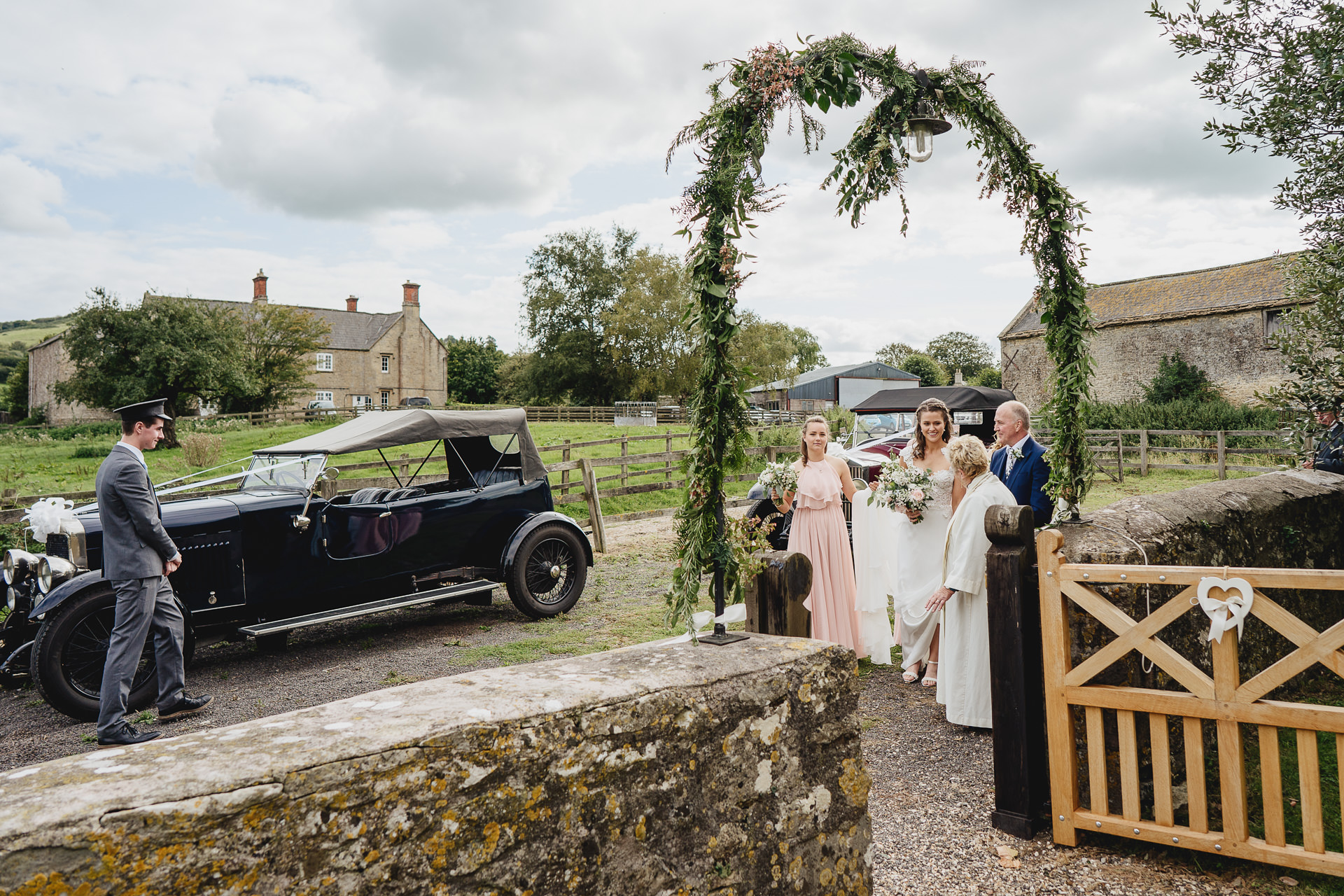 Bride and bridesmaids arriving outside a rural church