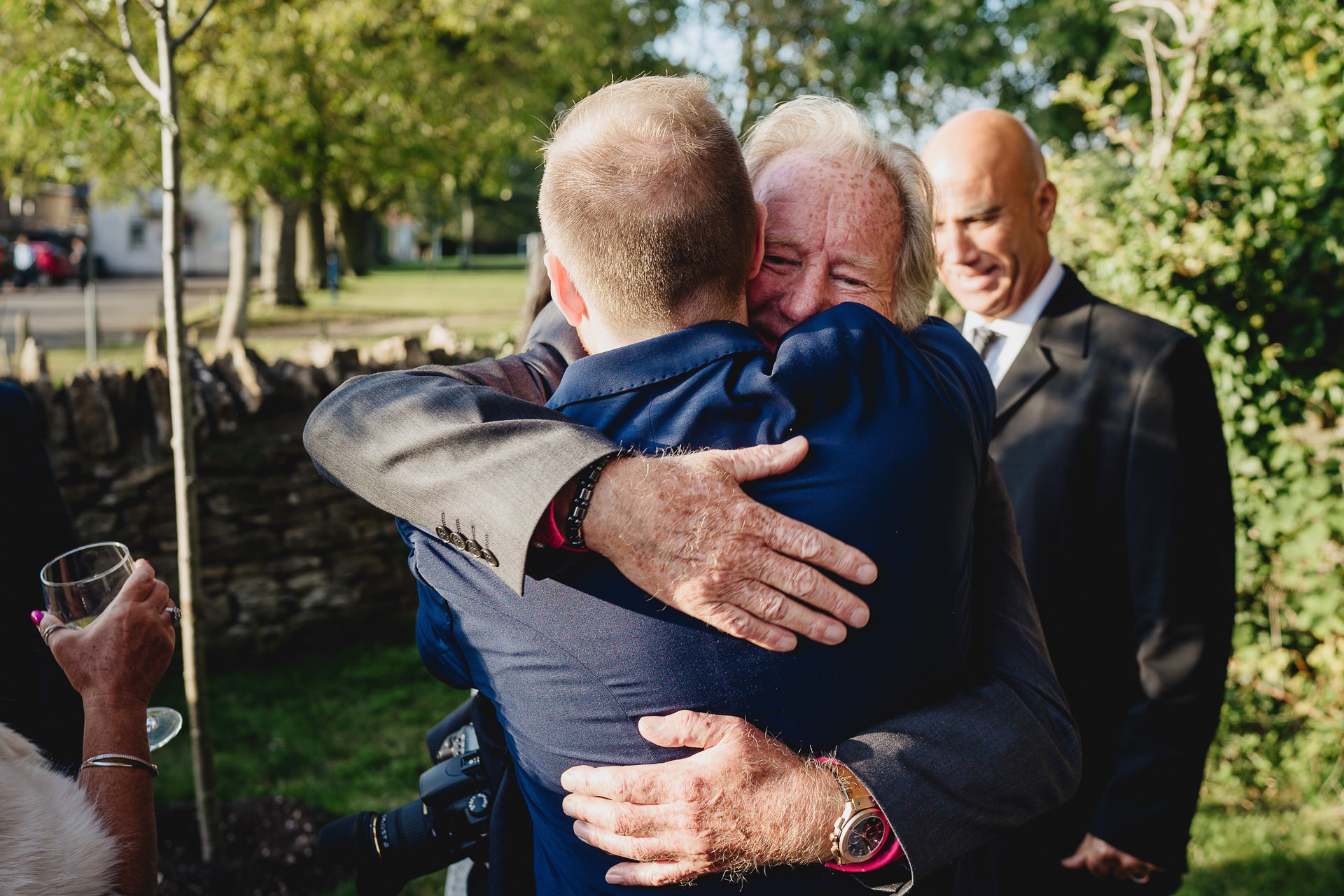 Groom and father hugging in a garden