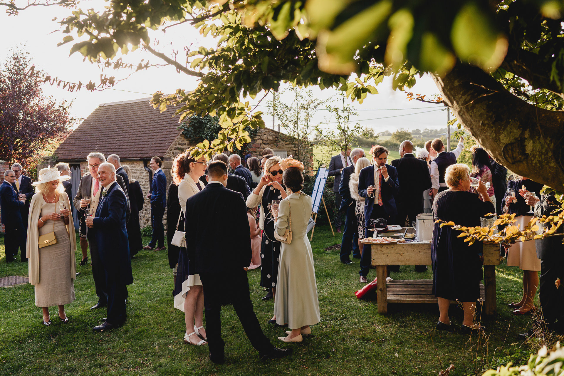 Wedding guests enjoying drinks and food in a garden