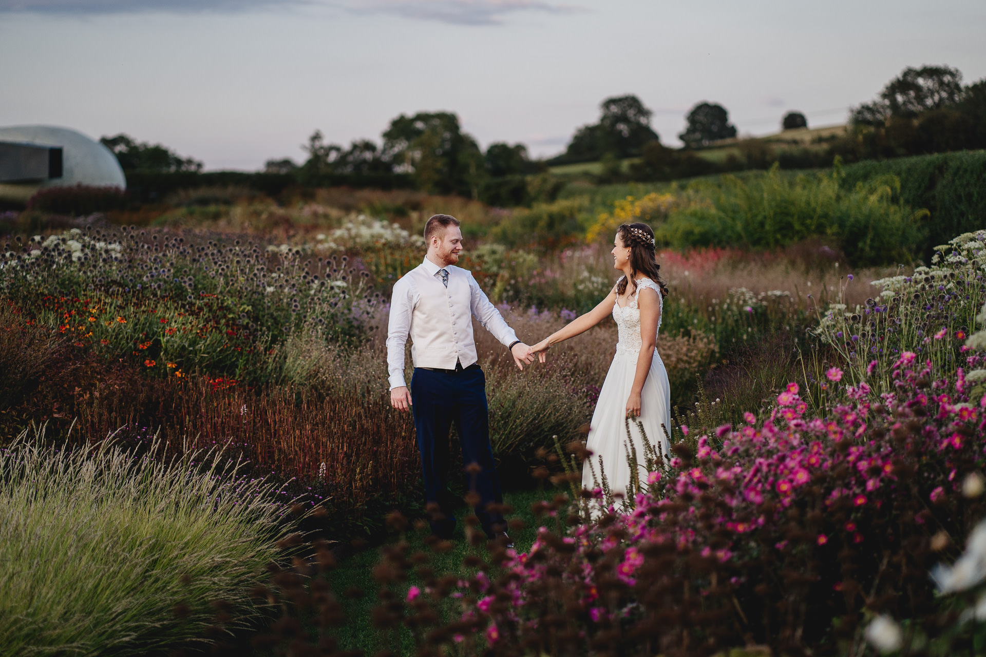 Bride and groom holding hands in gardens at Hauser & Wirth gallery Somerset