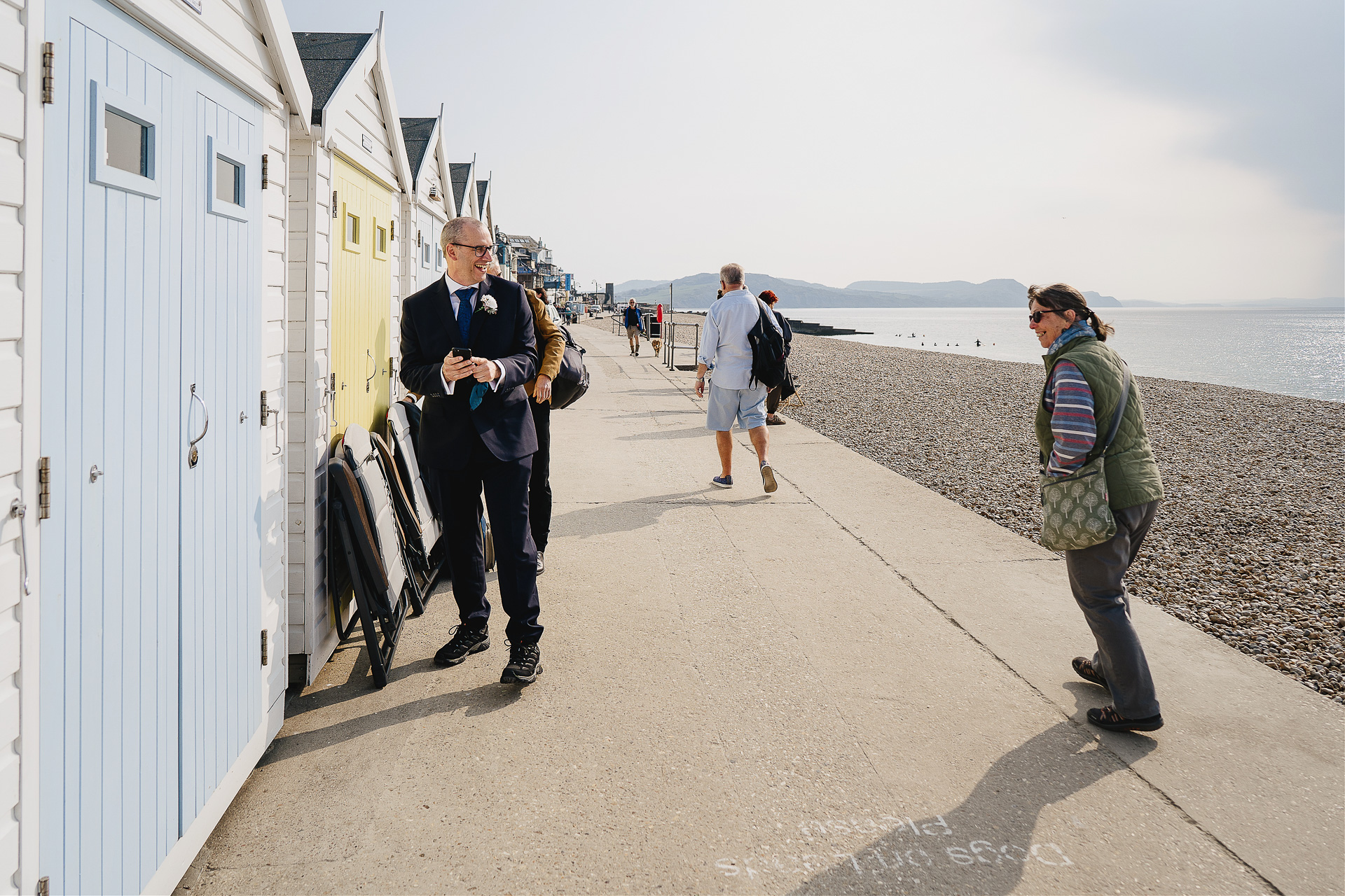 Groom opening a beach hut with passerby talking and smiling