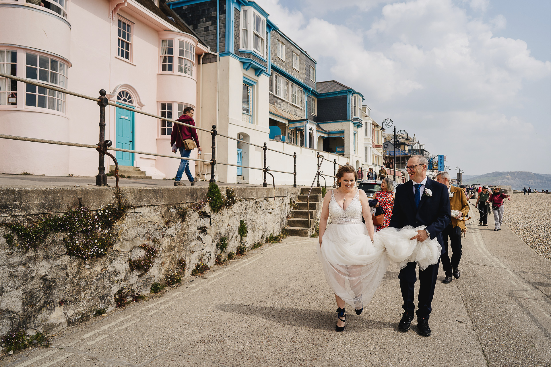 Elopement wedding by the sea, bride and groom walking along the seafront