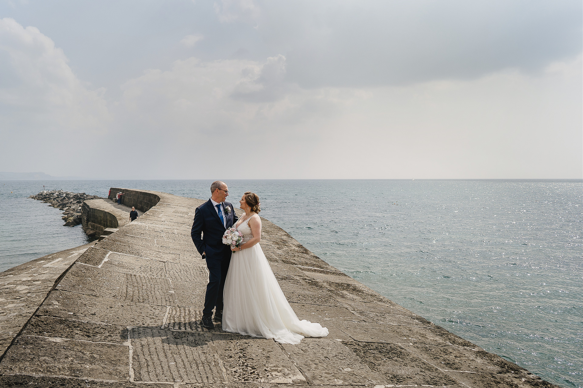 Bride and groom by the sea in Lyme Regis after their elopement wedding