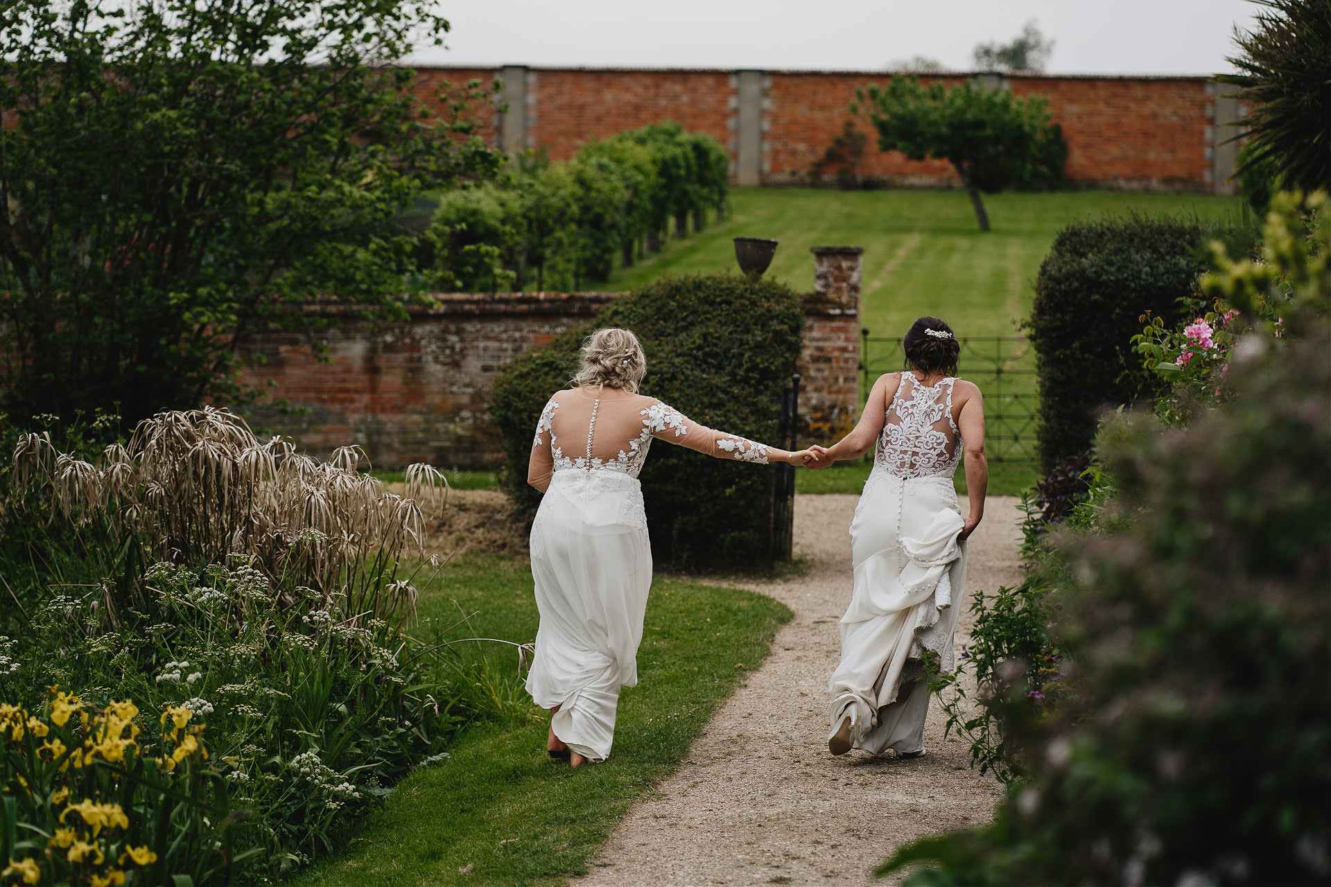 Bride and bride walking hand in hand at their Cadhay wedding