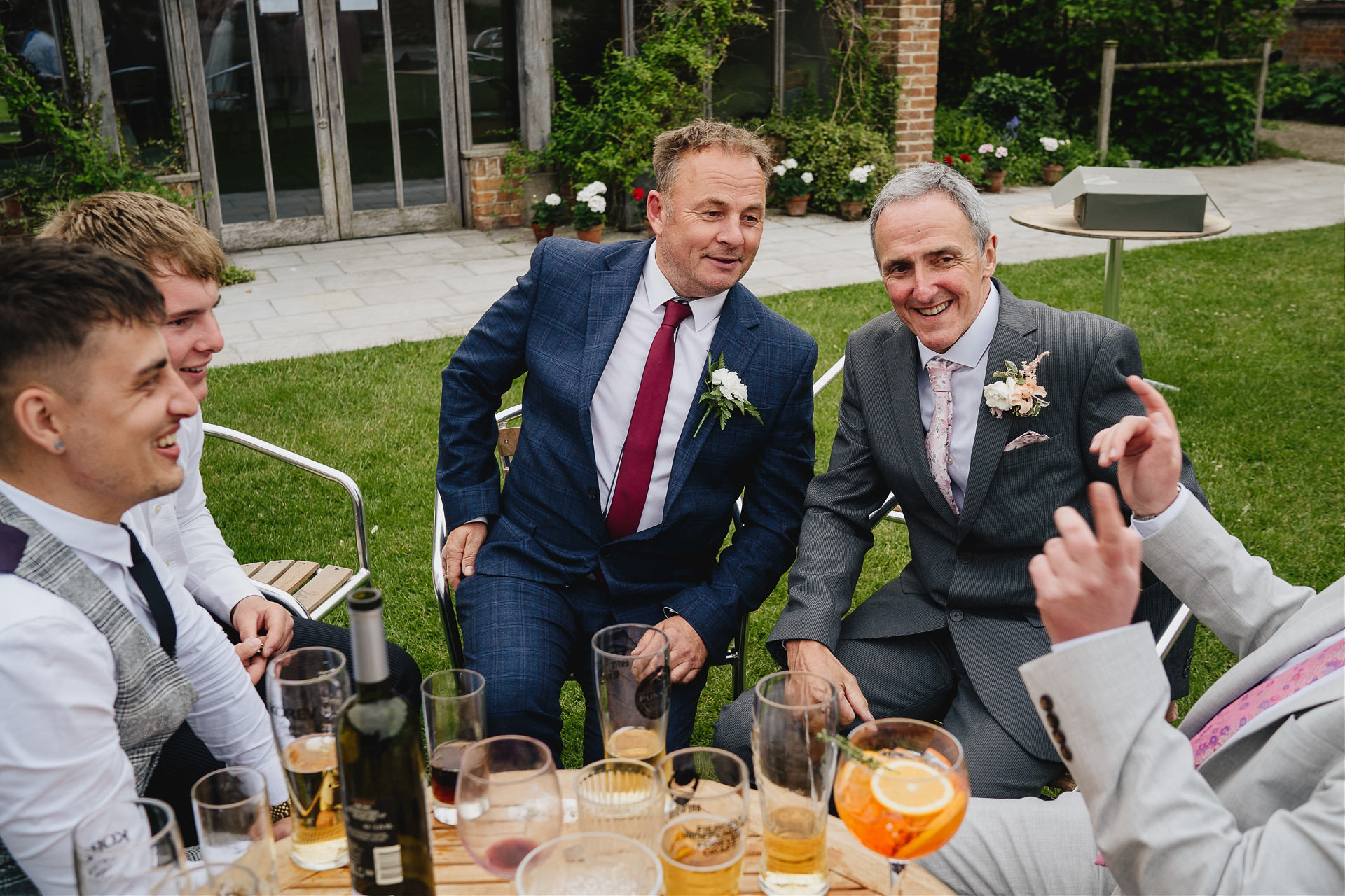 Wedding guests laughing around a table with drinks