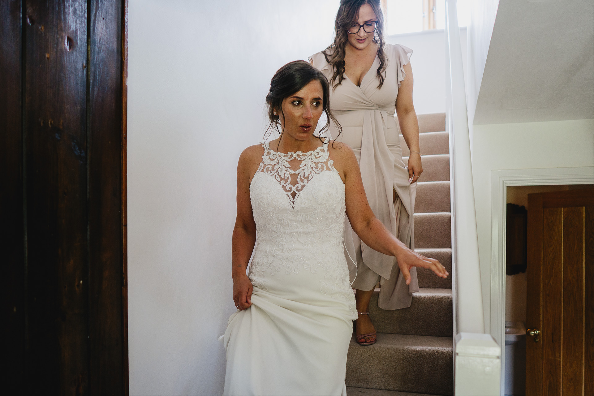 Bride coming down stairs with her sister, ready for Cadhay wedding
