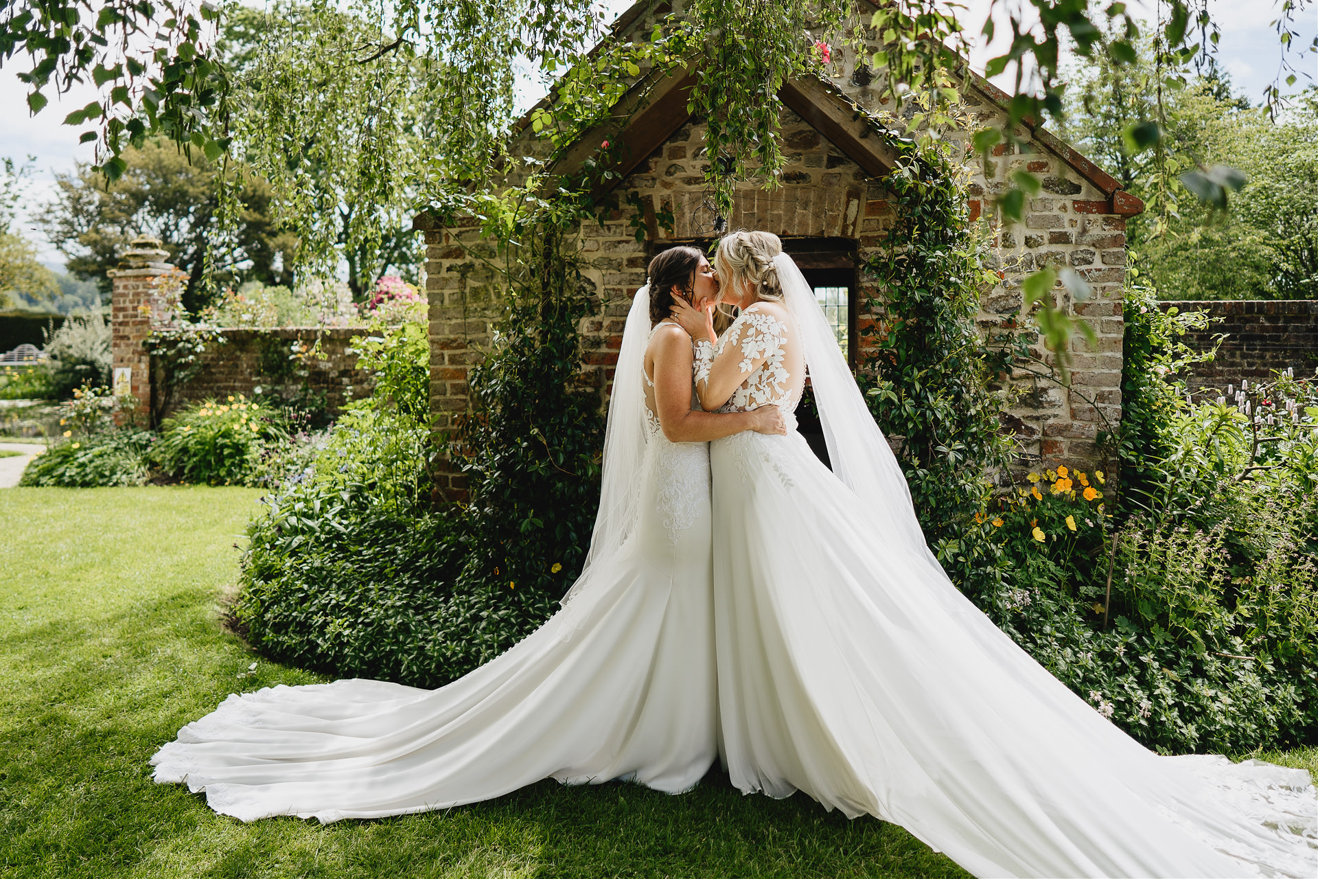 Bride and bride just married first kiss in a beautiful garden setting