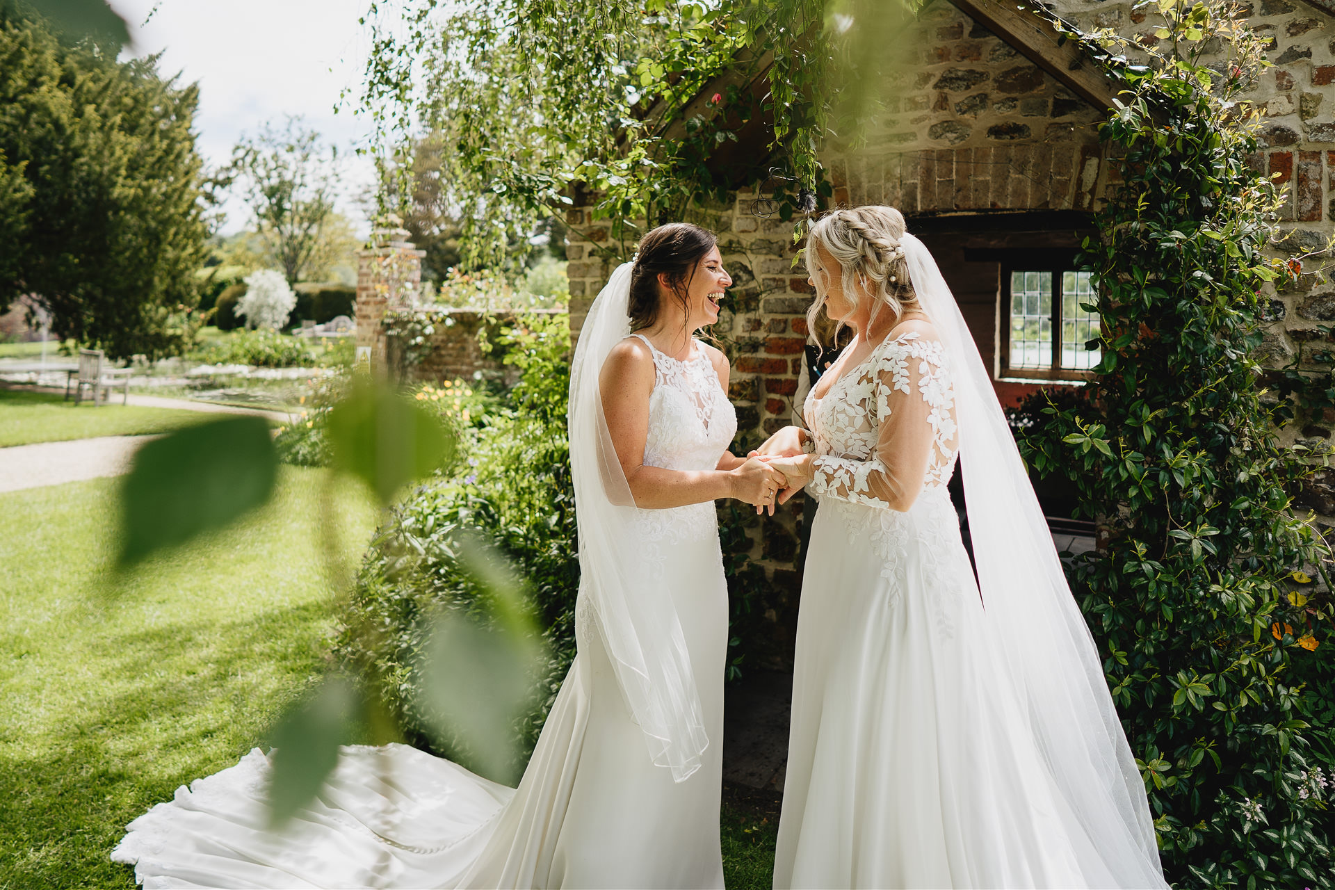 Two brides just married in an outdoor garden setting at Cadhay in Devon