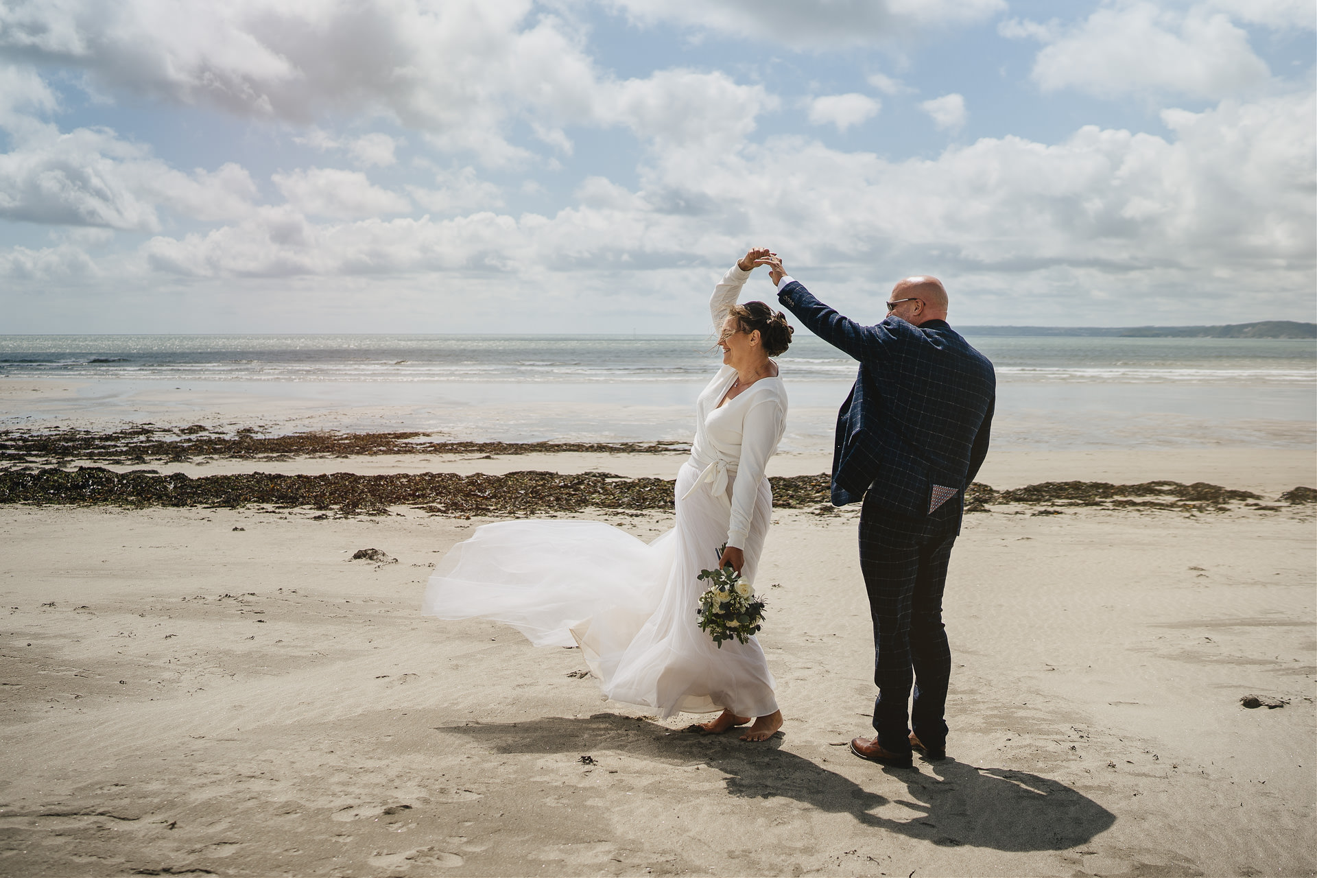 Bride and groom dancing on a Cornwall beach together