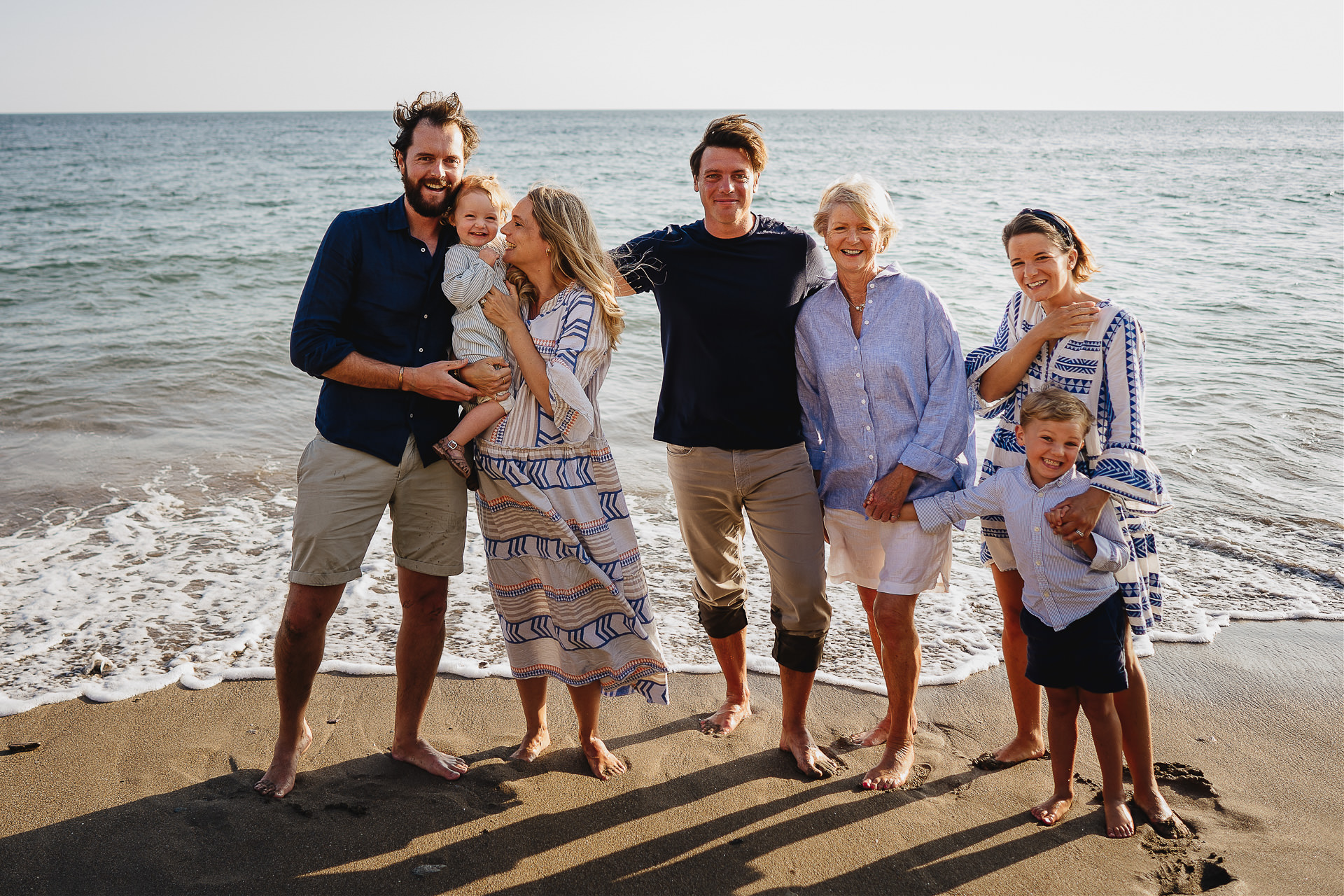 A relaxed family photograph on the beach at sunset