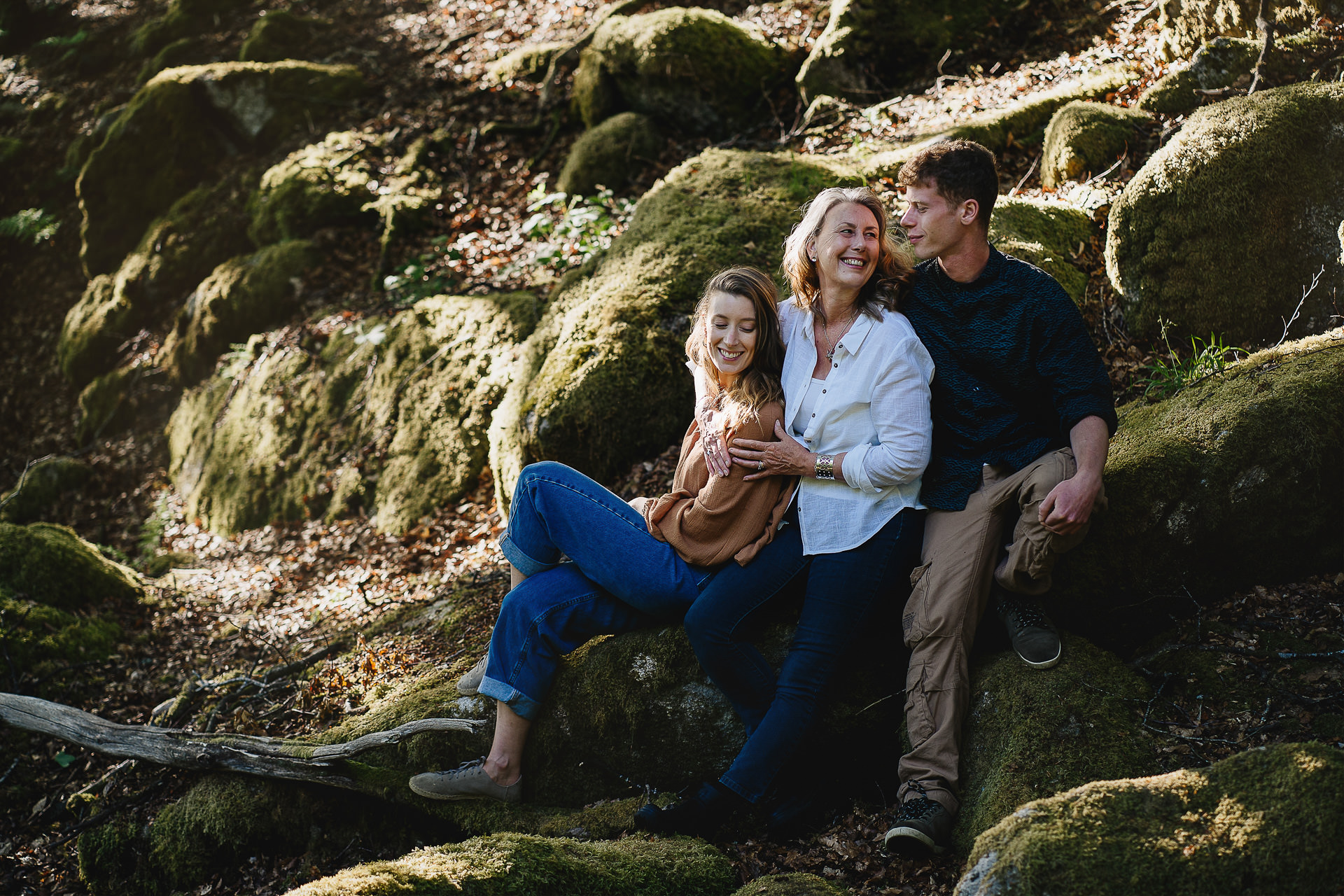Family group photo on moss covered rocks in woodland