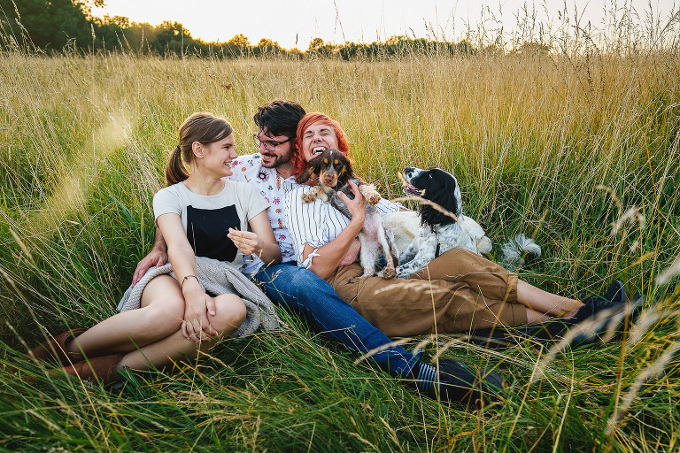 Family photography of a family group laughing together with dogs