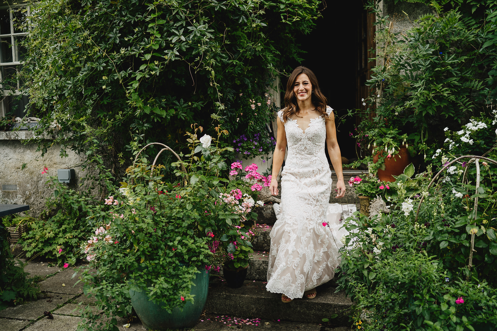 A beautiful bride down steps surrounded by garden flowers