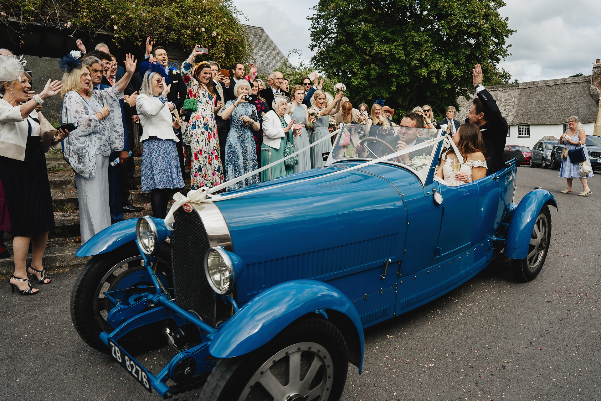 Bride and groom leaving church in a wow factor vintage wedding car