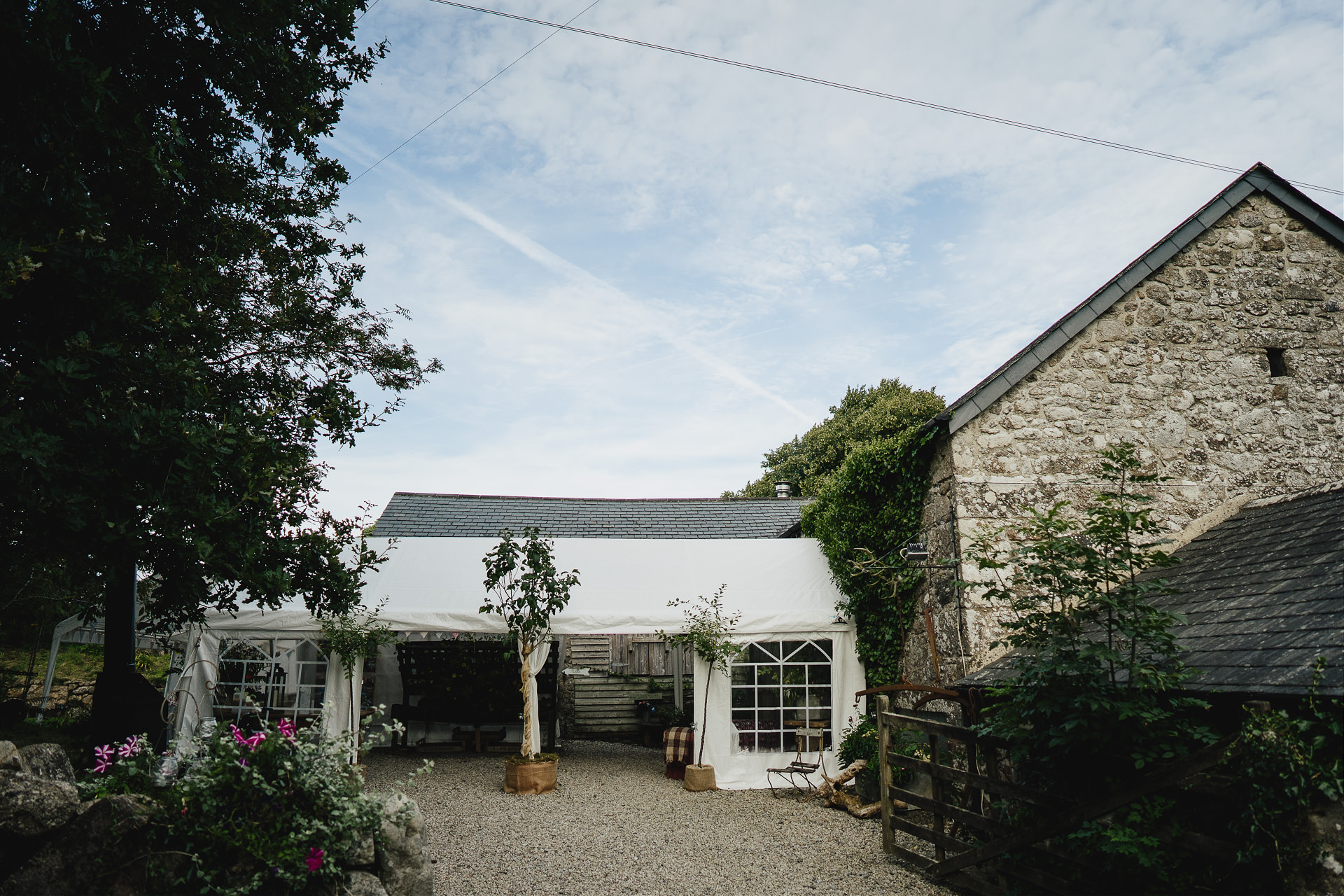 Exterior view of a beautiful old barn with a wedding marquee attached