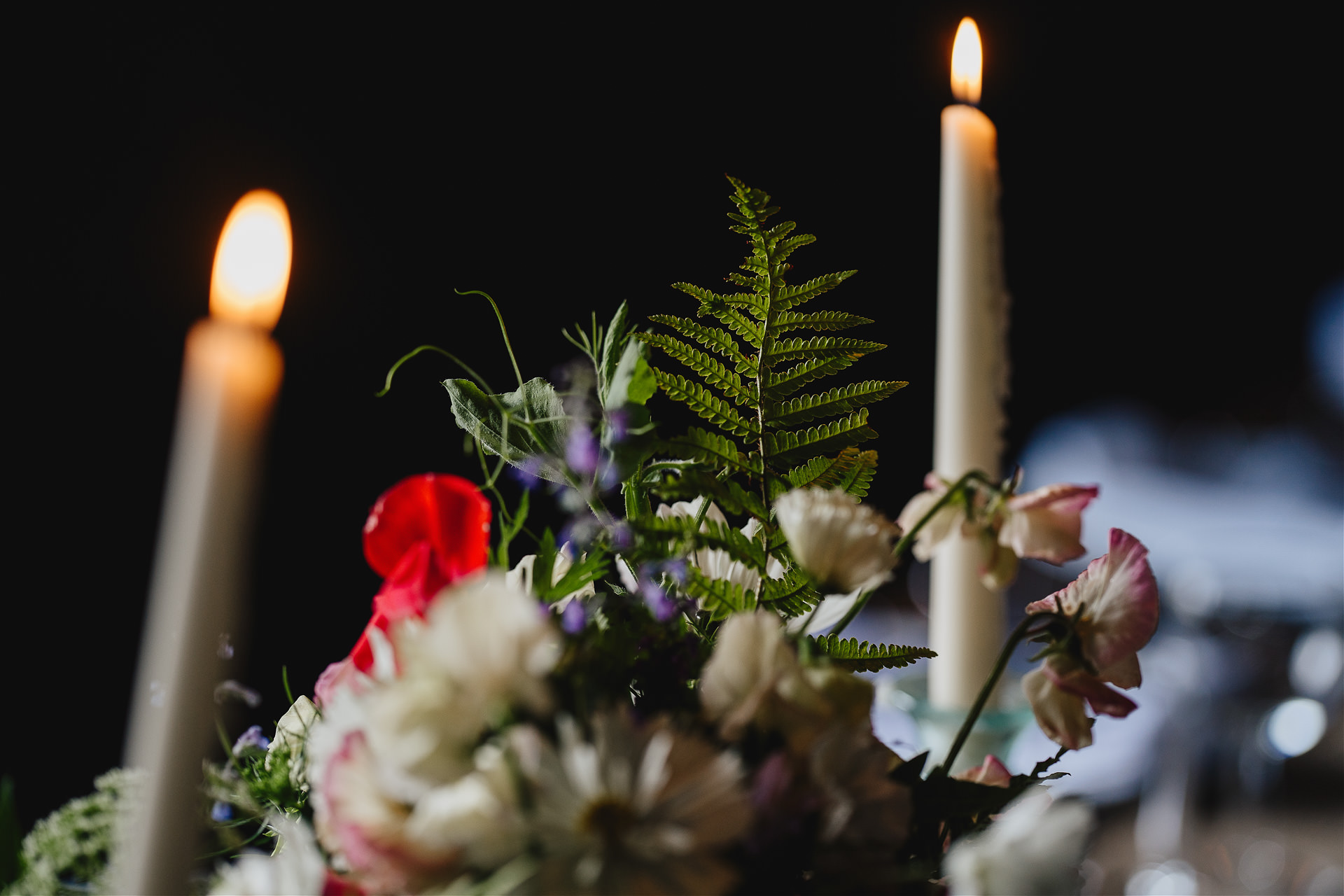 Wow factor table flowers and candles inside a beautiful dark wedding barn