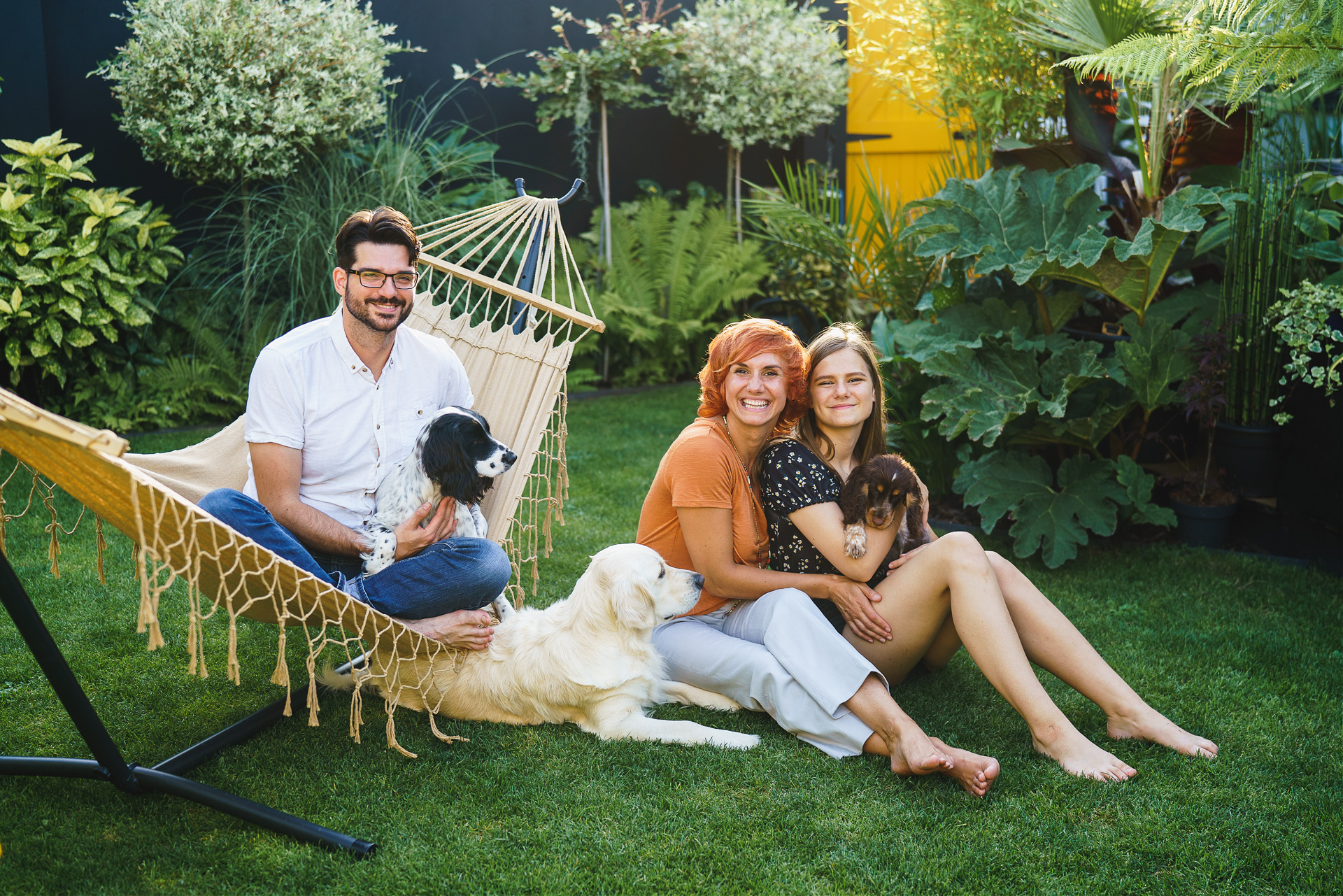 Photo of a family with three dogs in a garden together