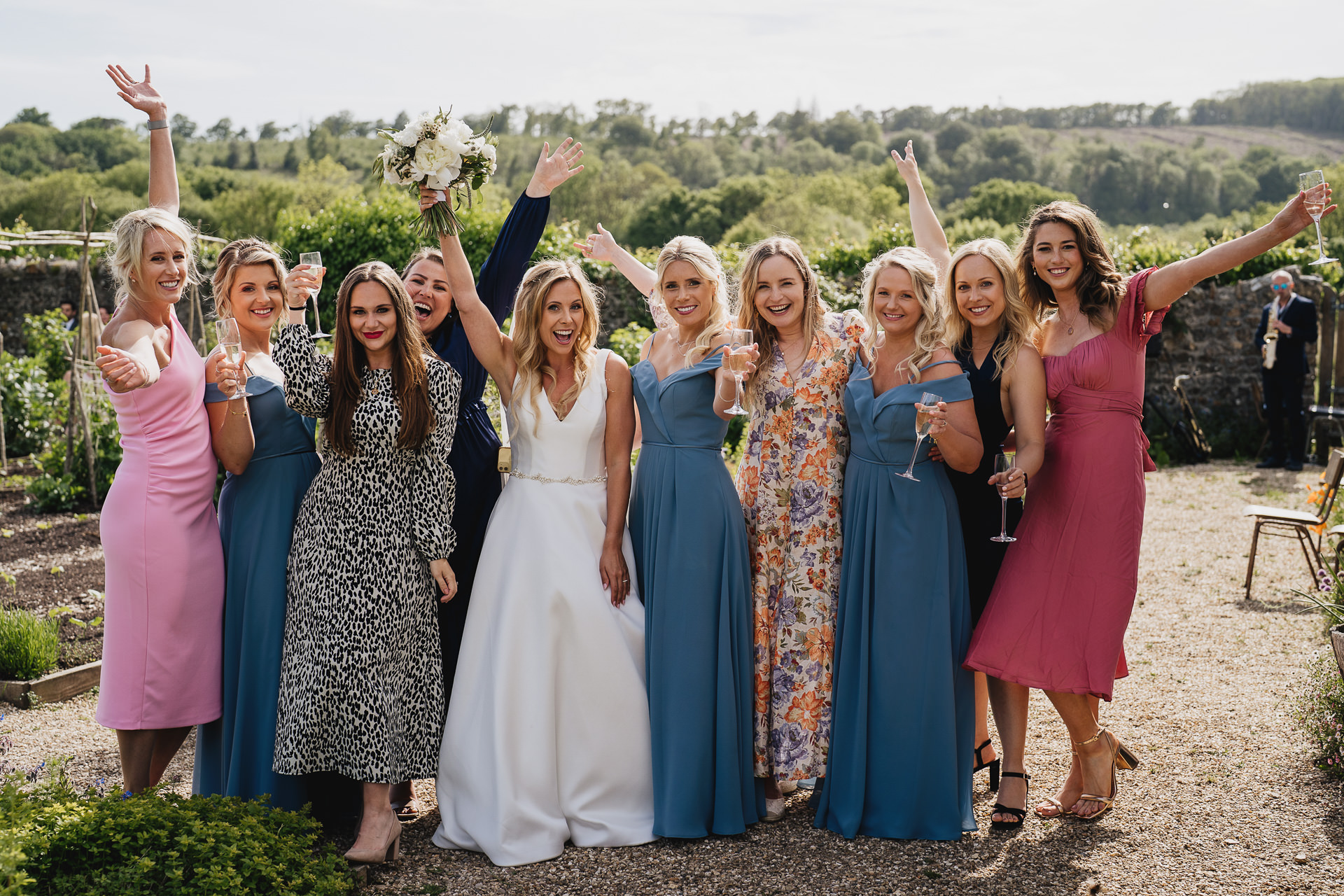 Bride with a group of female wedding guests smiling at the camera