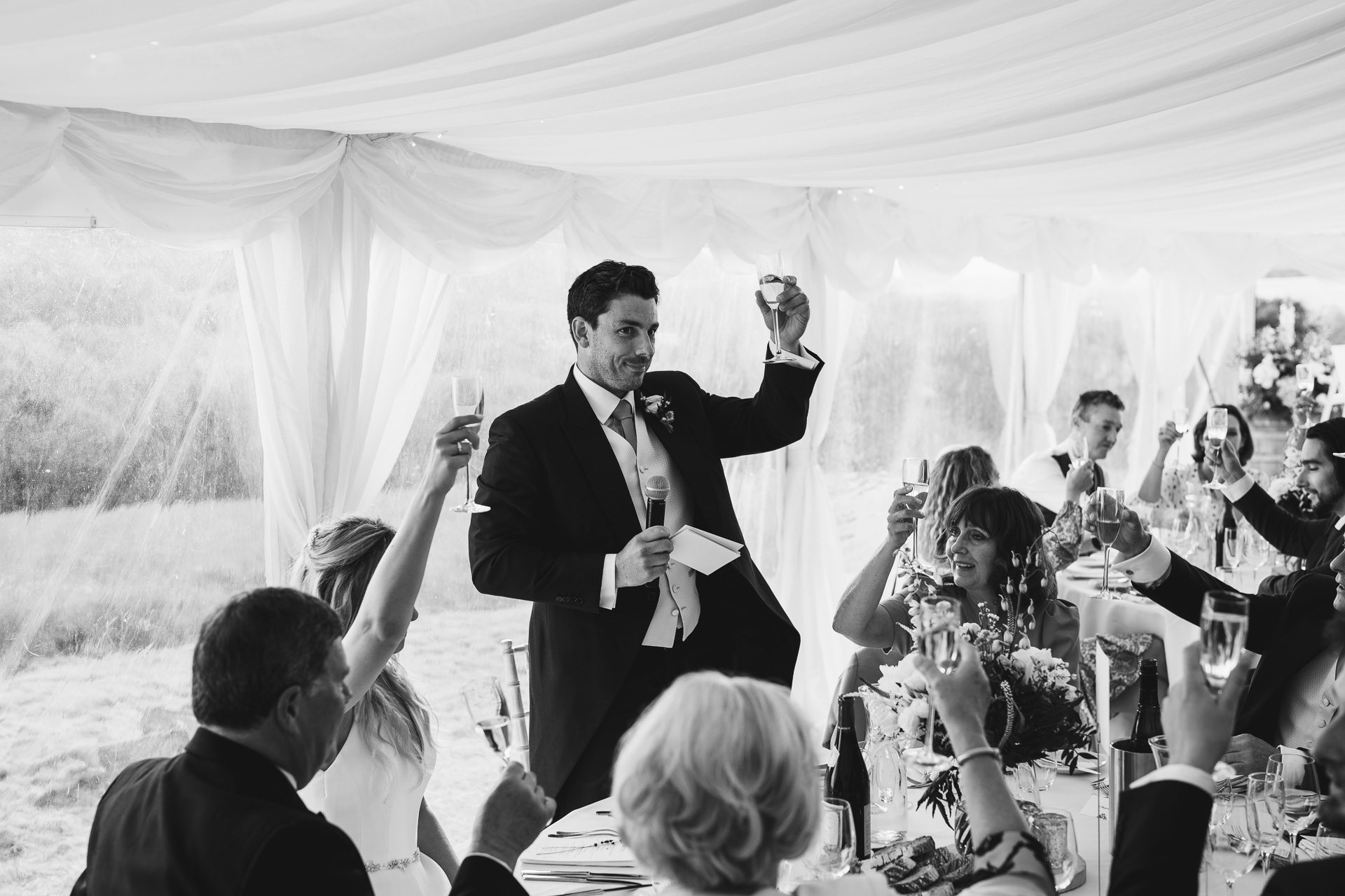 Groom raising a toast during a wedding at River Cottage
