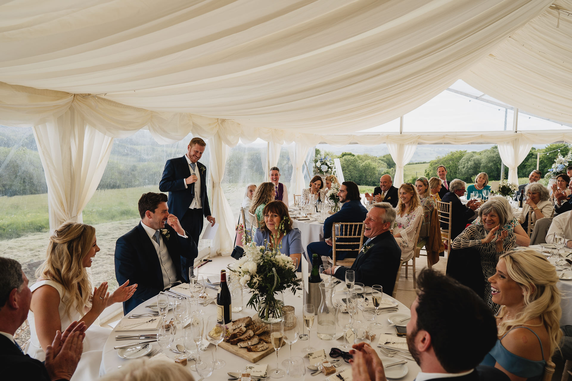 Wedding guests laughing at best man's speech at a wedding at River Cottage