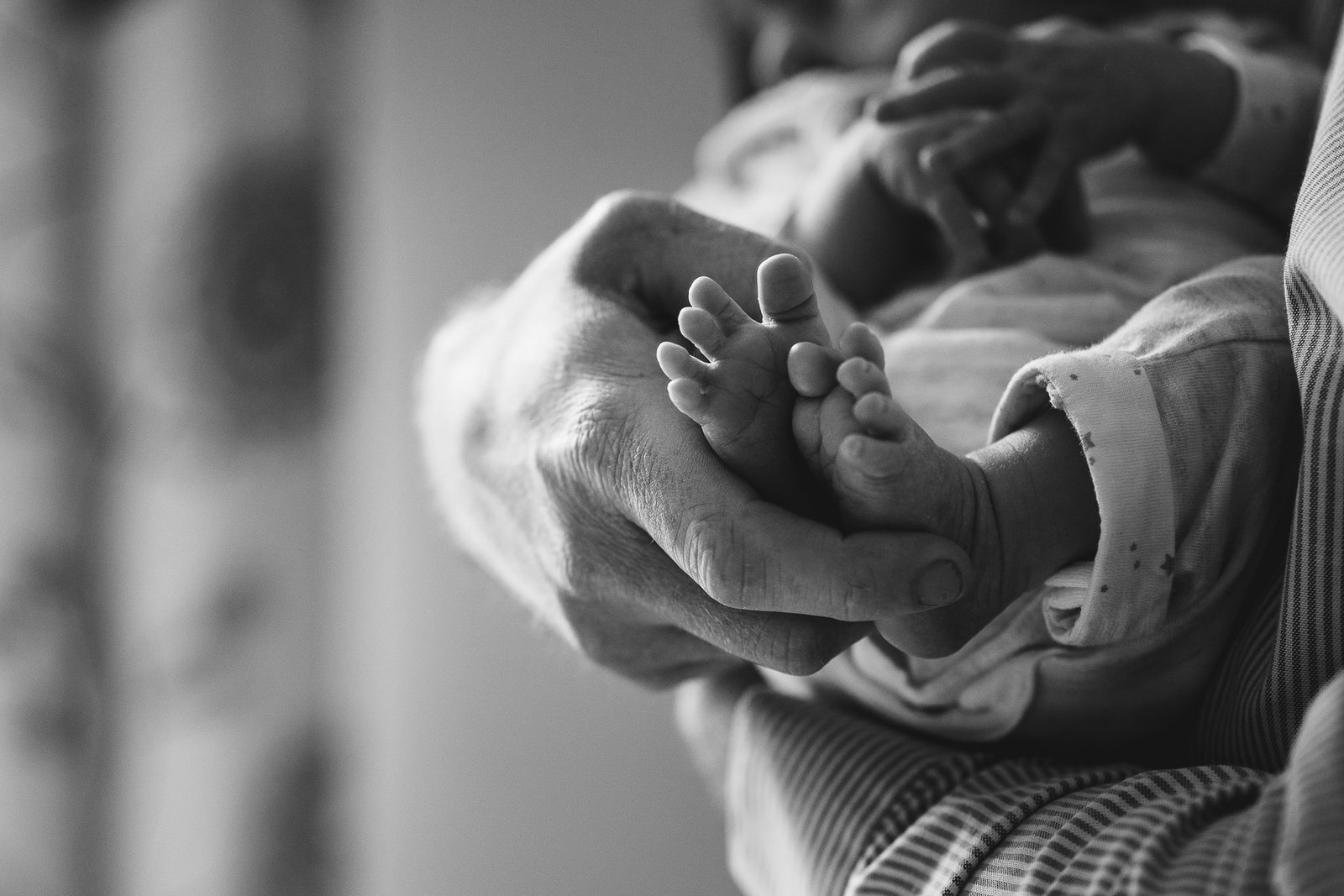 A newborn baby's feet in close up, being held my a parent, during a newborn photography session in Devon. 