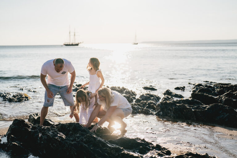 A family looking in rock pools together during an evening photography session