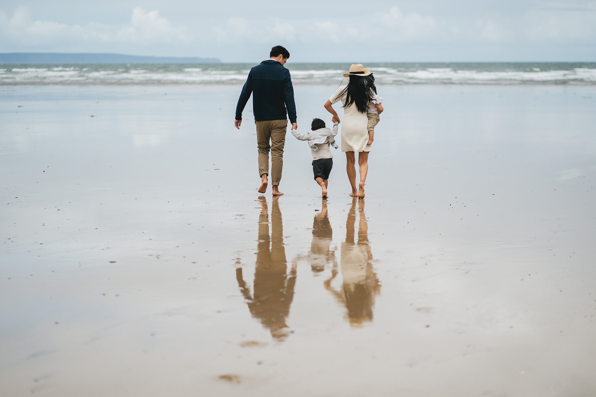 A family walking across the beach together during a Saunton Sands family photography session