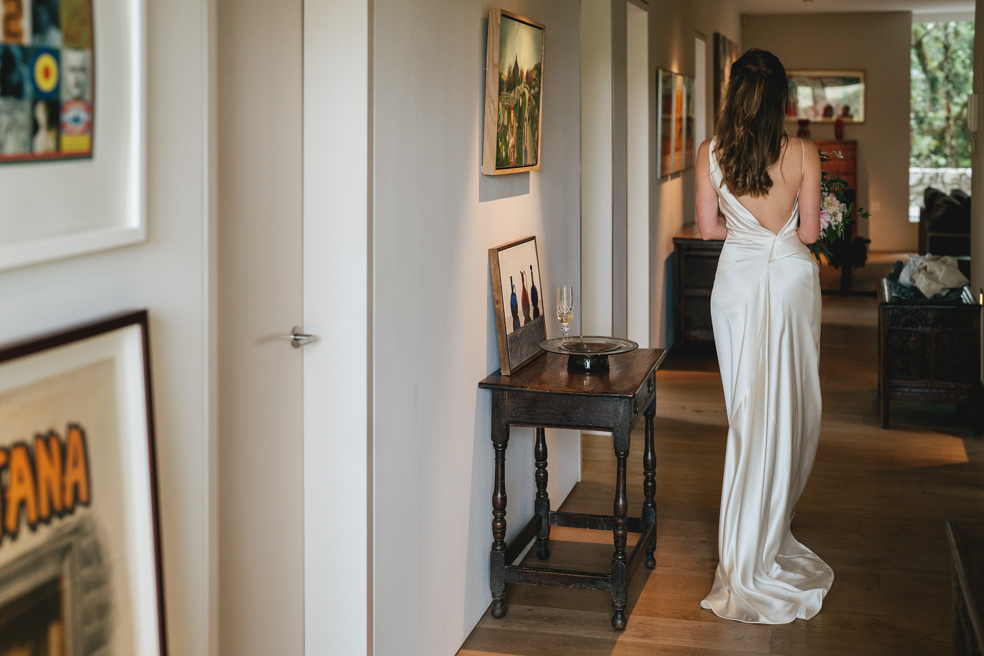 Indoor portrait of a bride in a stunning Vivienne Westwood wedding dress, seen from behind