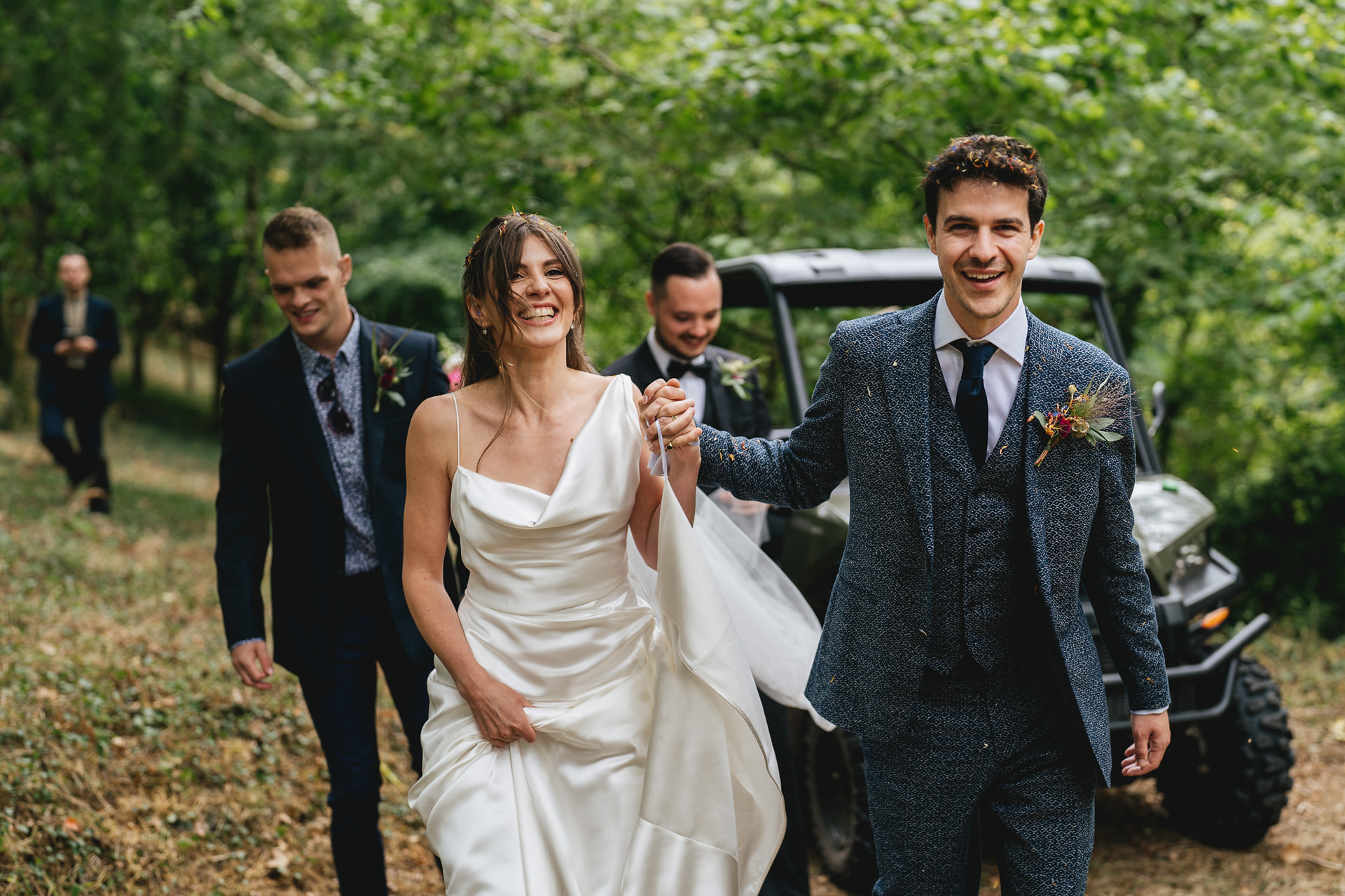 A bride in Vivienne Westwood and groom in a bespoke Casely Hayford suit walking through the woodland on Dartmoor together