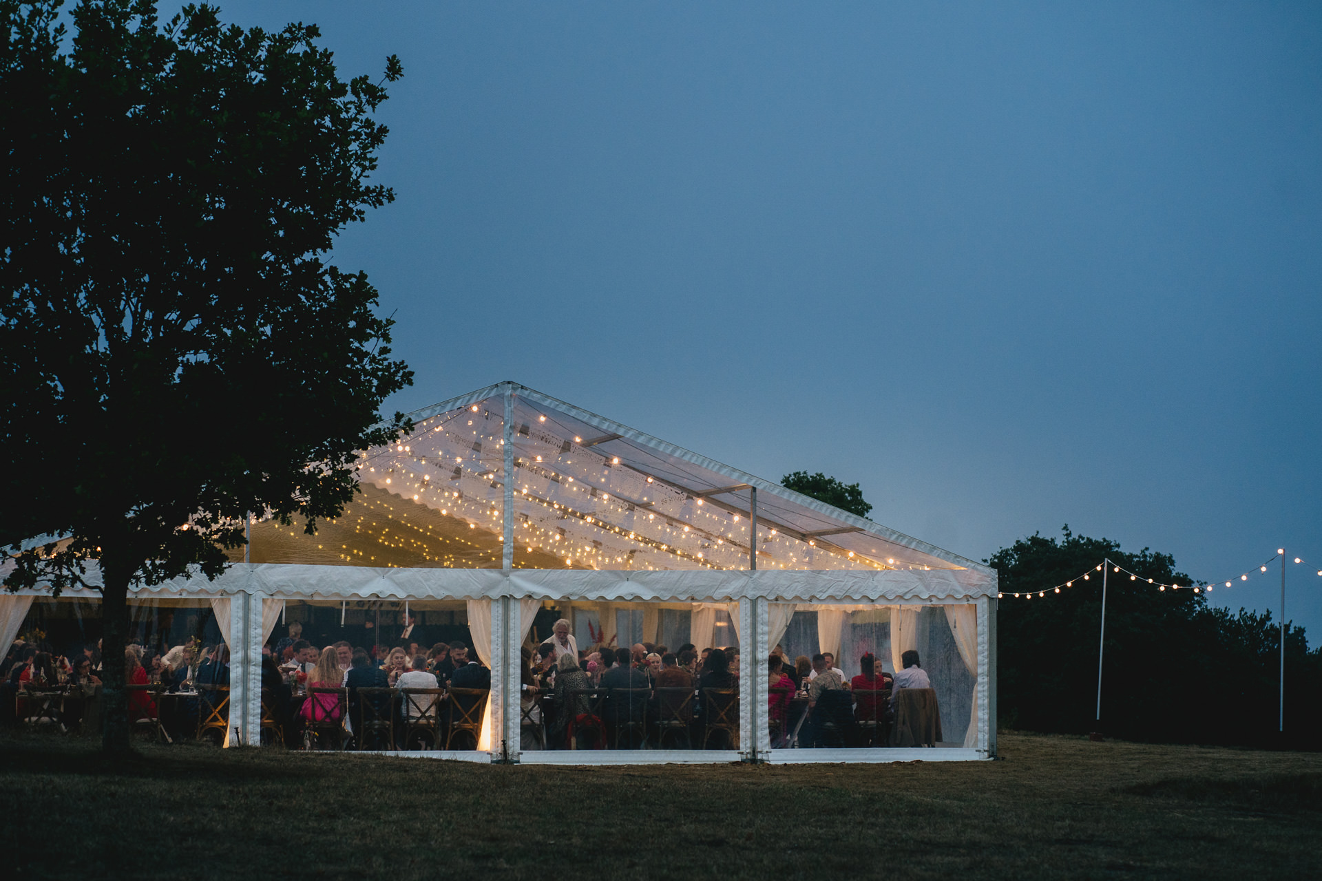 A marquee on Dartmoor with twilight skies and twinkling lights from the marquee