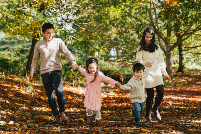 A family walking through woodland in the autumn, on a family photography session in Exeter