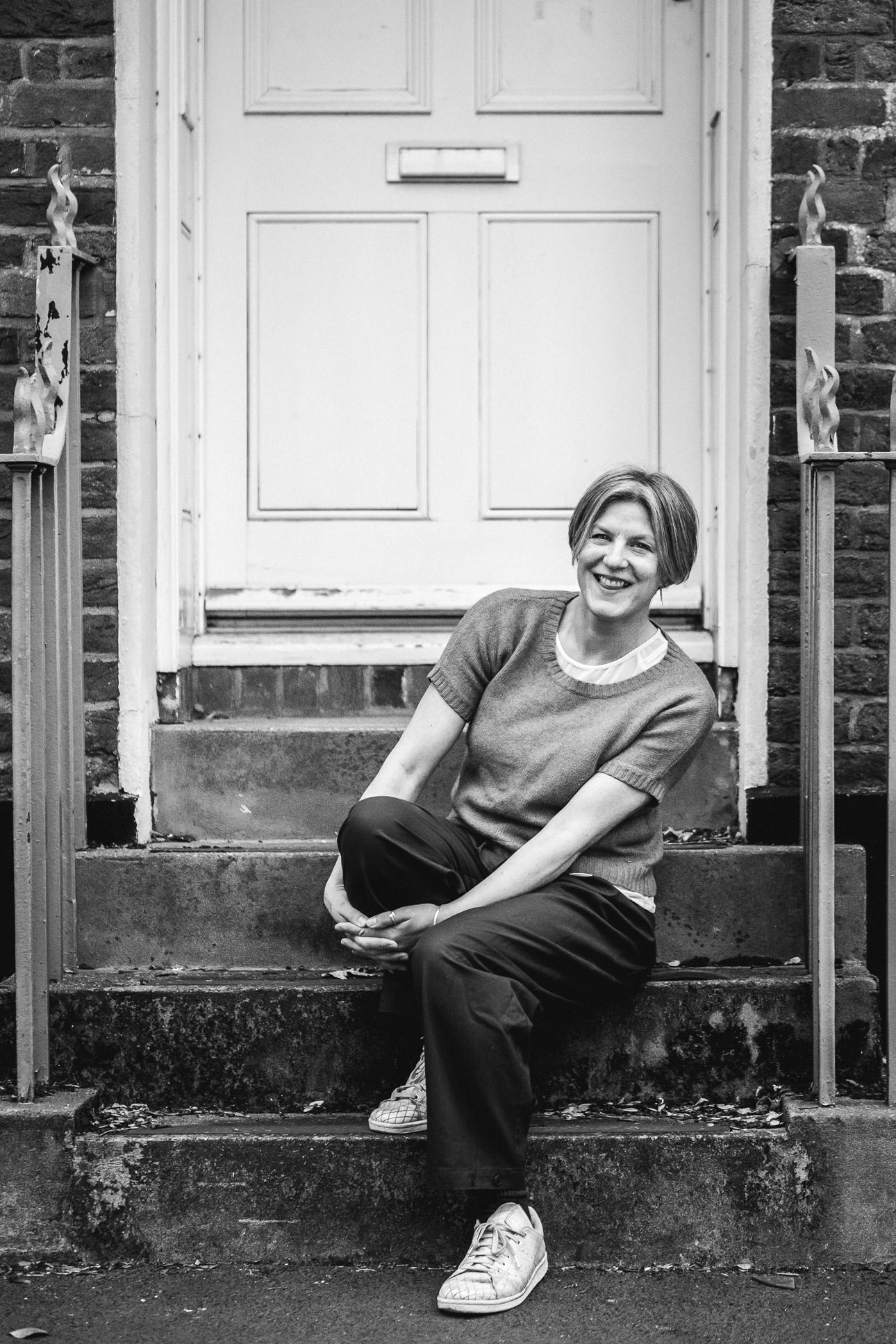 Photographer Helen Lisk sitting on some stone steps and laughing