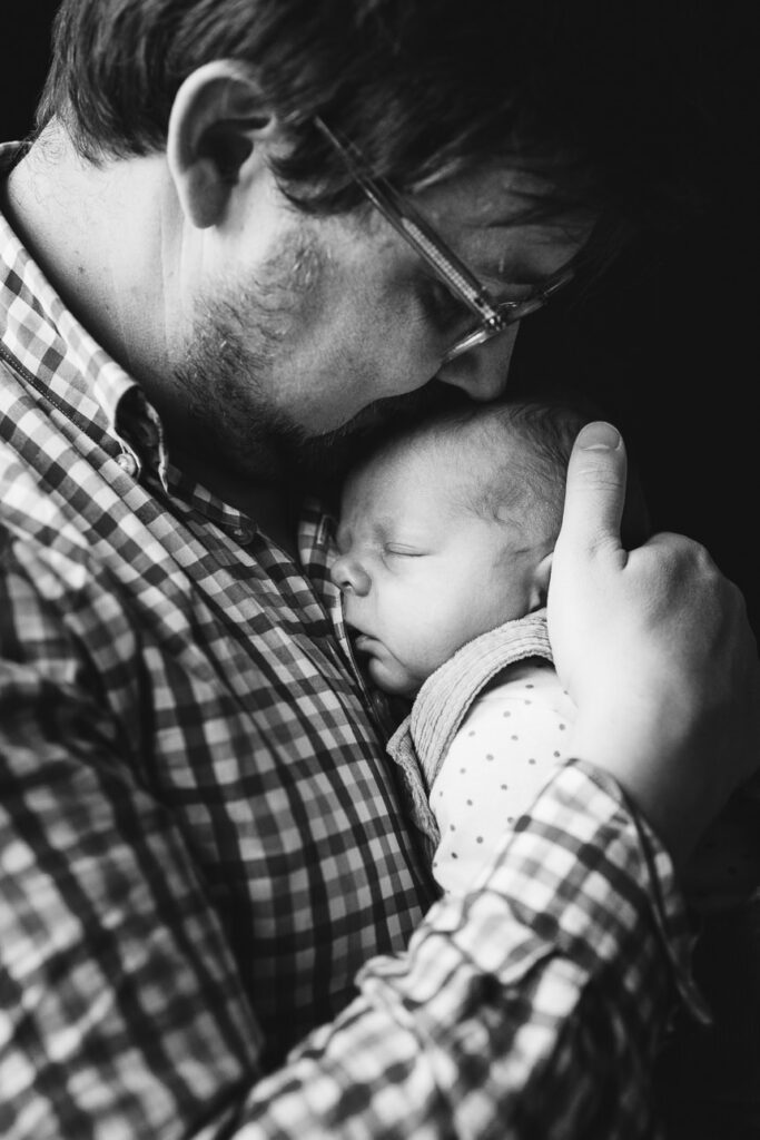 A father cuddling a newborn baby