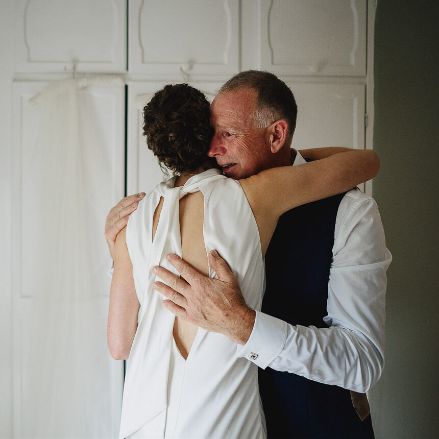 A father emotionally embracing his daughter on her wedding day