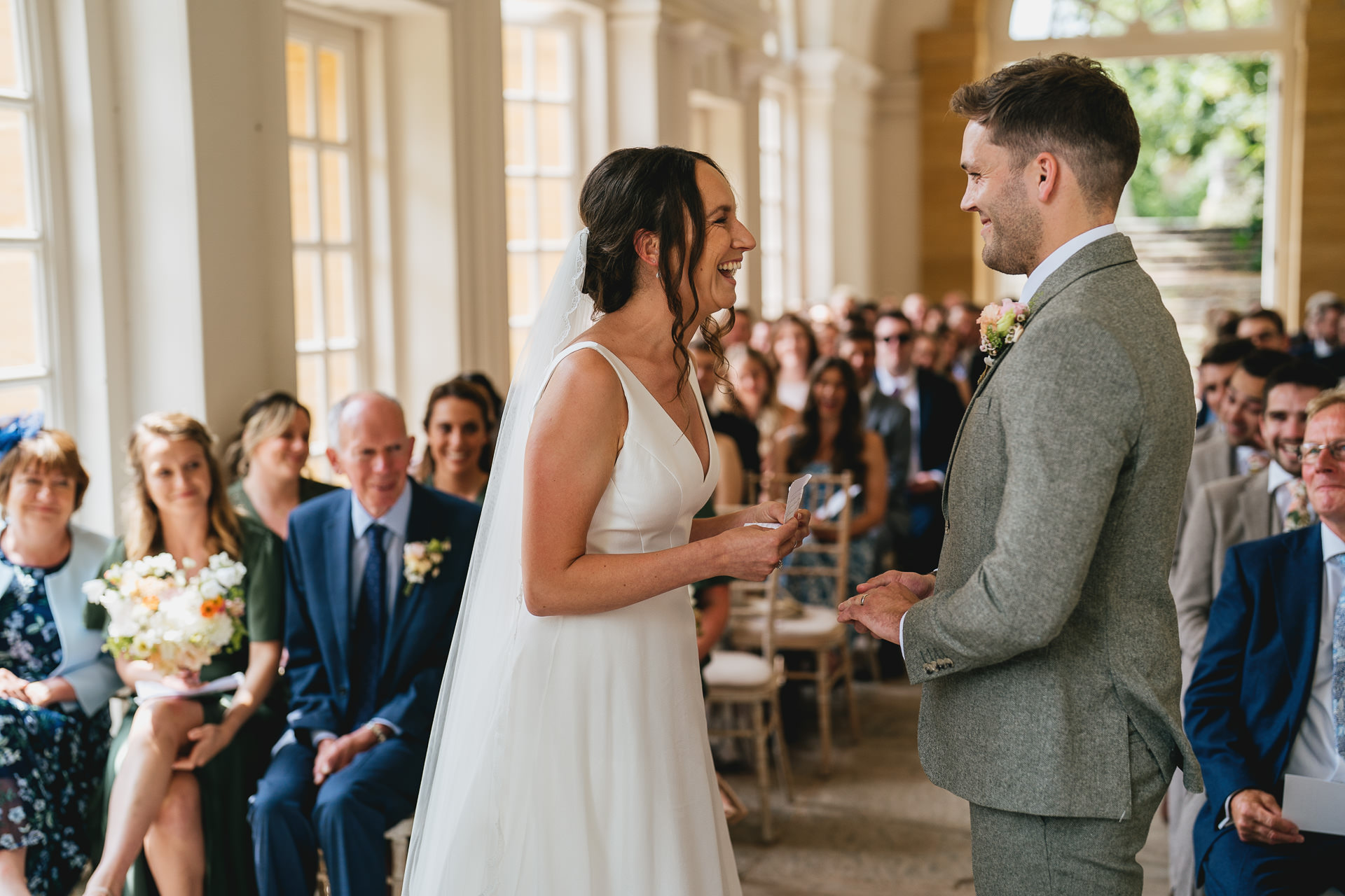 The bride and groom laughing together at their wedding in the orangery at Hestercombe Gardens