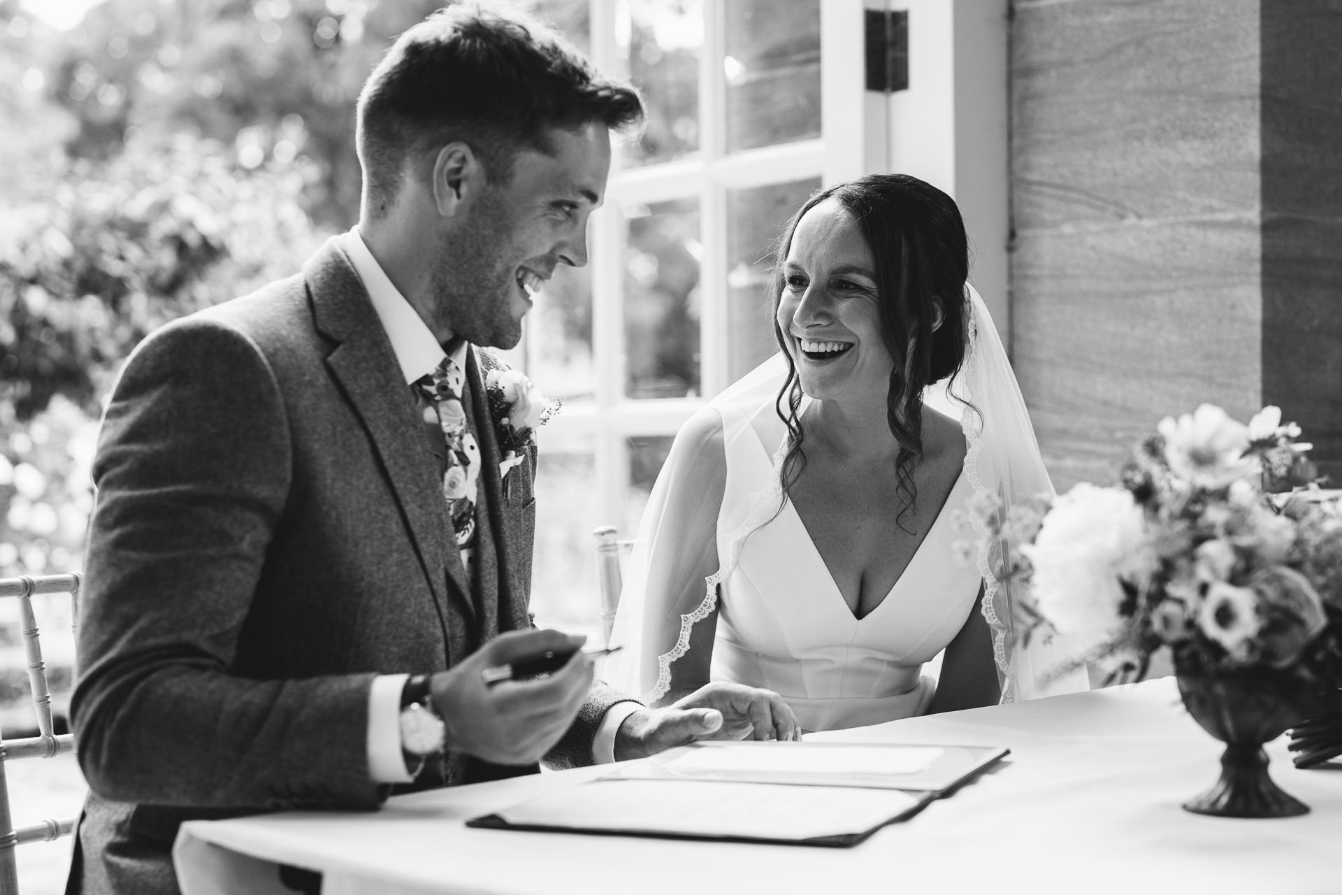 A bride and groom signing the register at the Orangery in Hestercombe