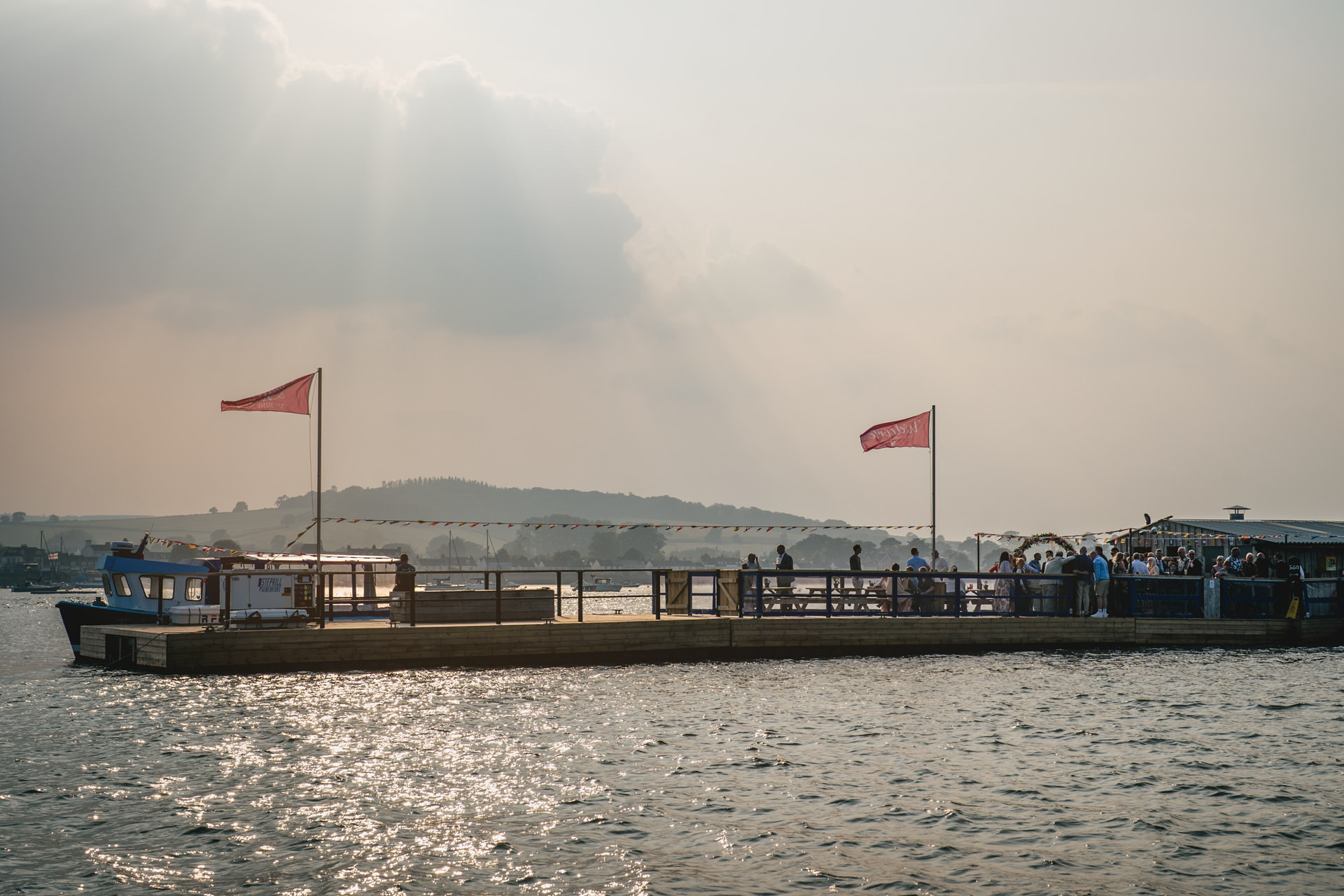 A hazy sunset over the River Exe Cafe with wedding guests on board