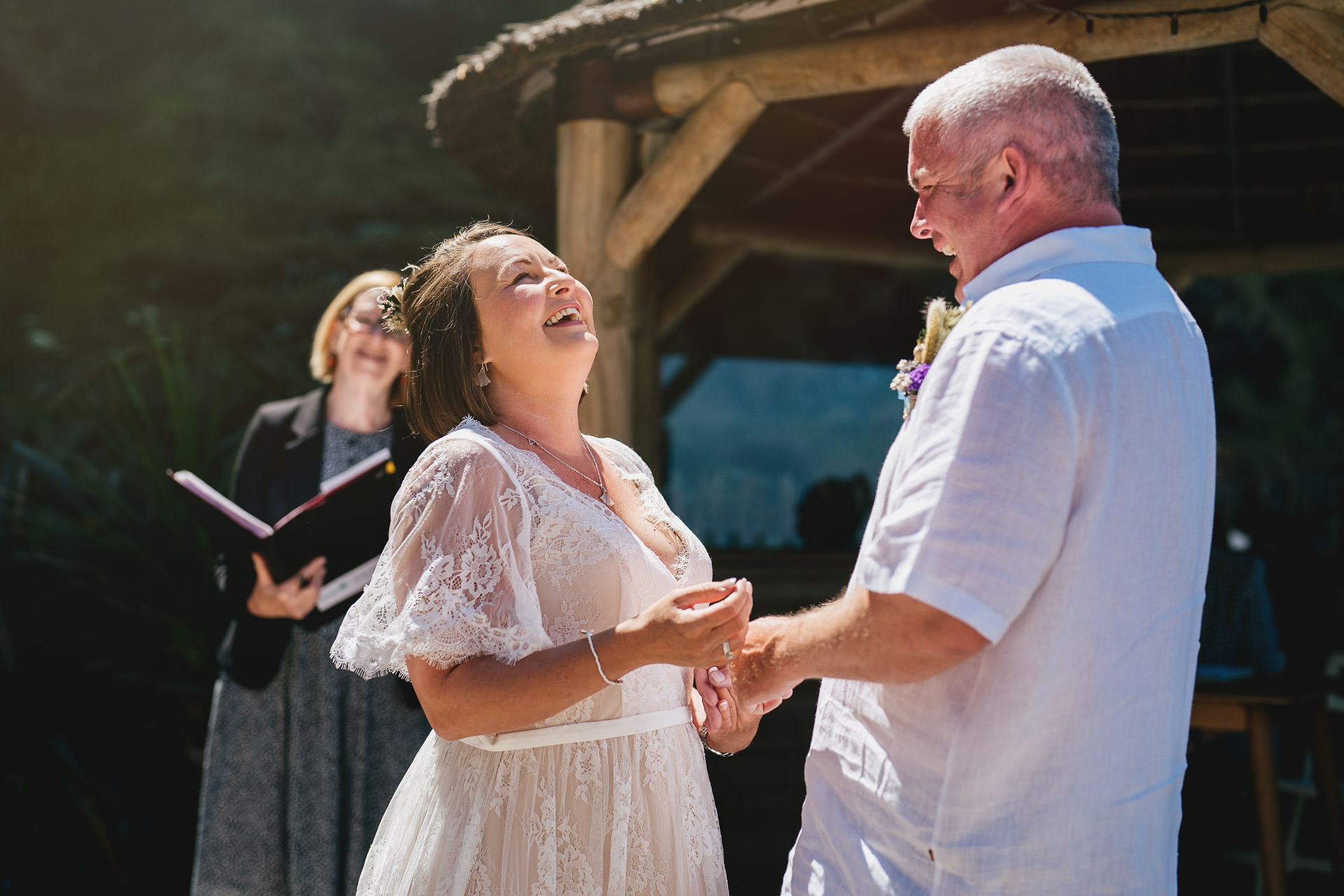 A bride and groom laughing during their wedding ceremony at Tunnels Beaches