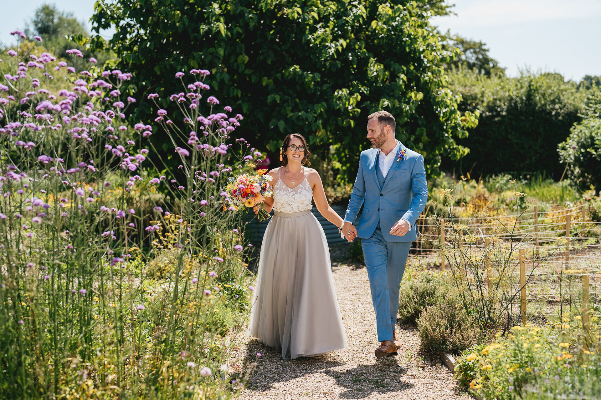 Bride and groom walking through the kitchen garden after their elopement wedding