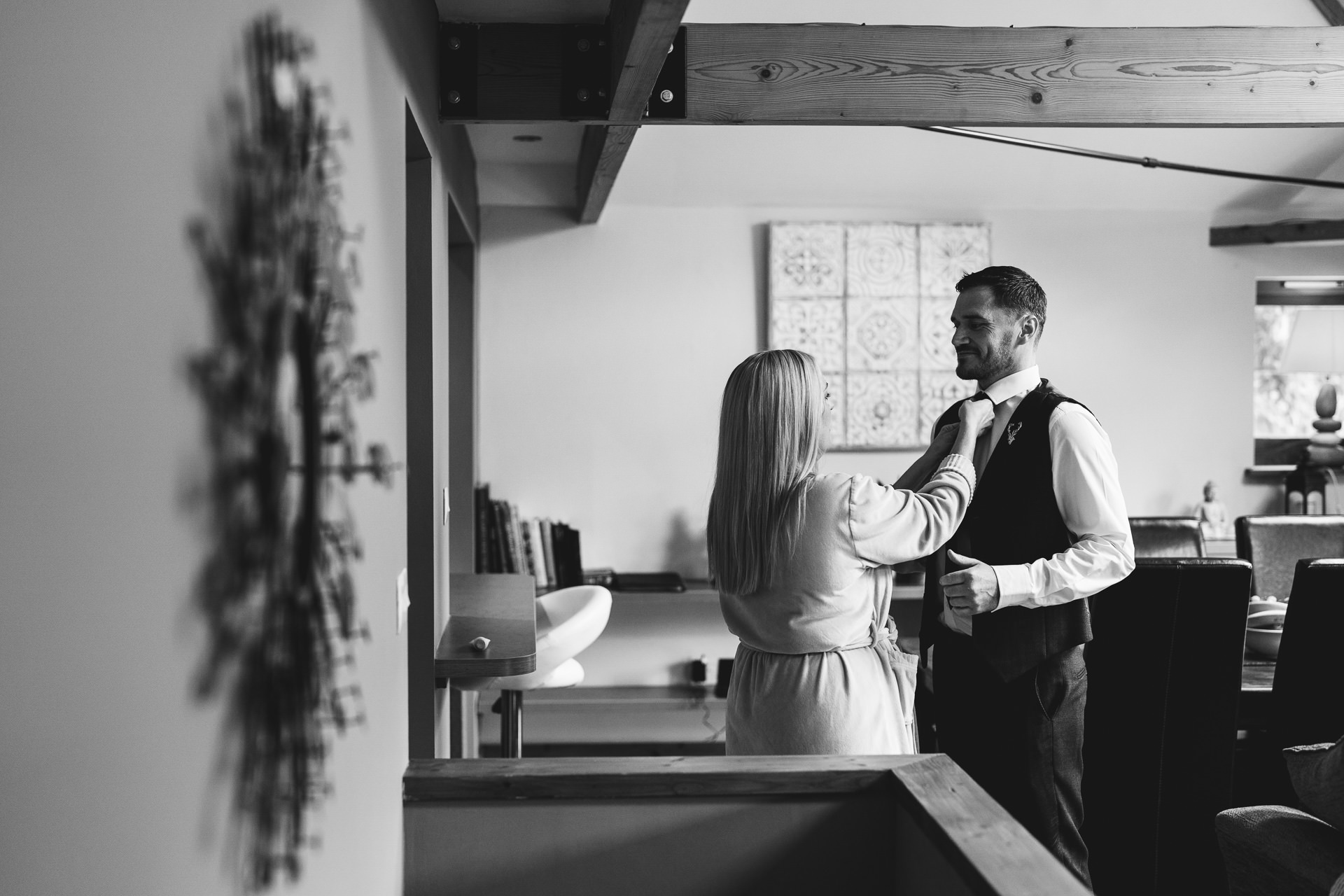 A couple checking each other's clothing getting ready for their elopement wedding