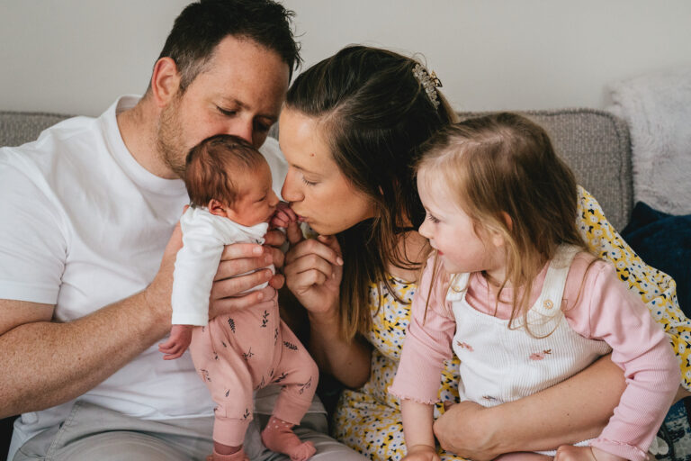 A family cuddling together with a newborn baby in their Taunton home