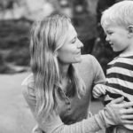 A mother and son smiling at each other on the beach during a family photography session in Devon