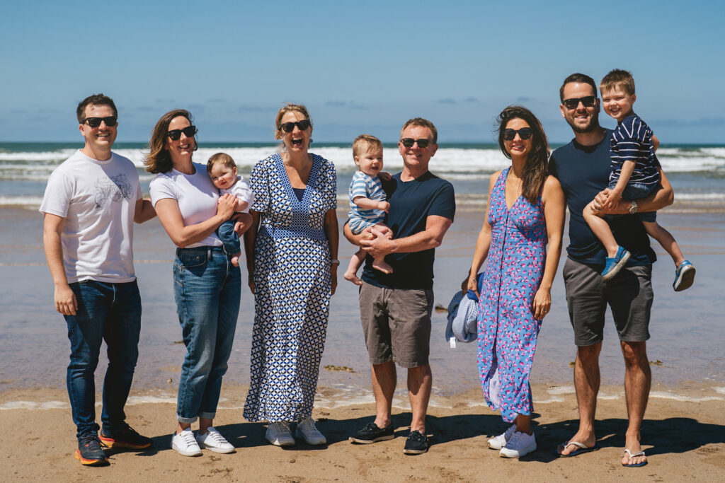 Family photography on the beach in bright sunlight in the summer