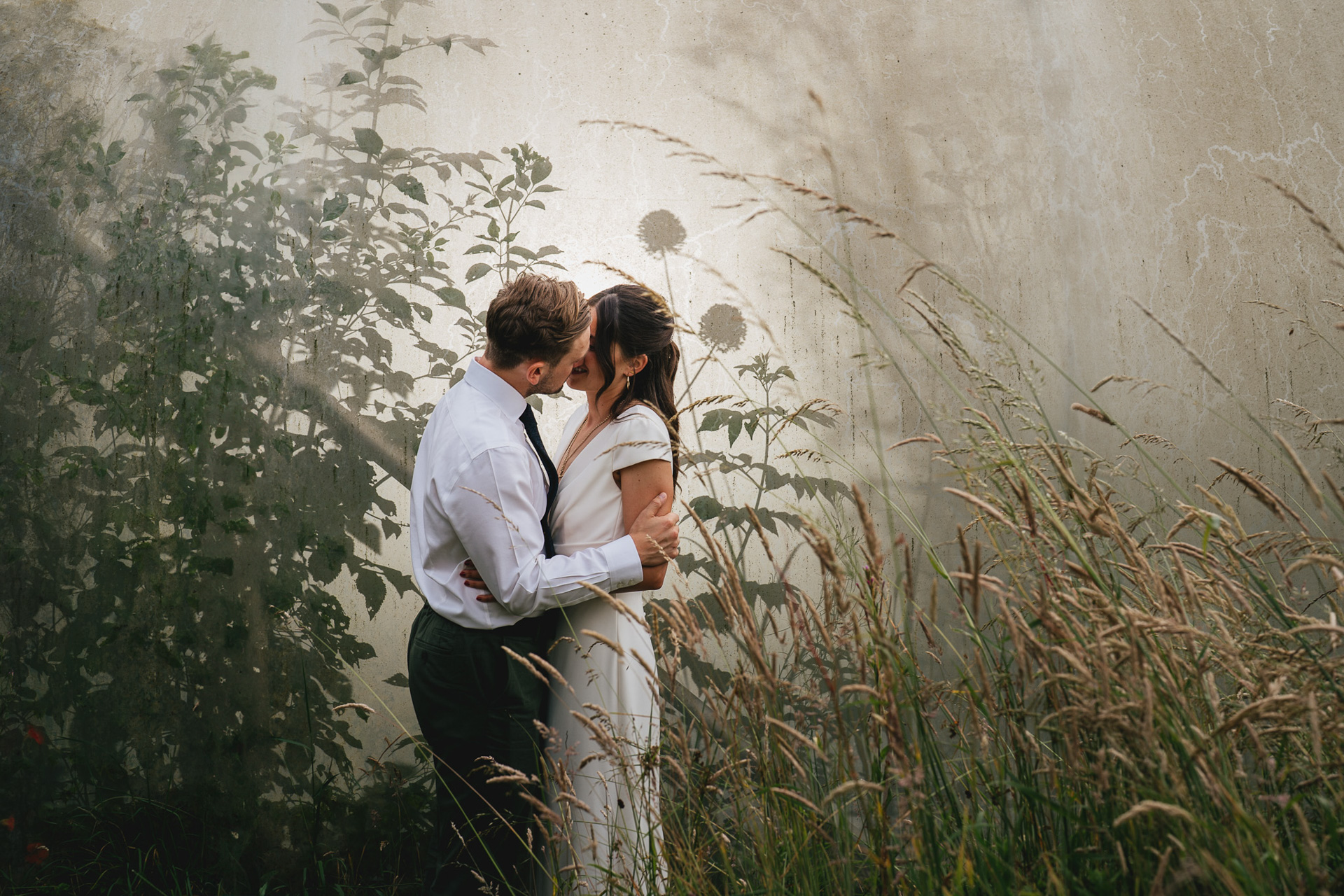 A bride and groom in front of foliage at River Cottage 