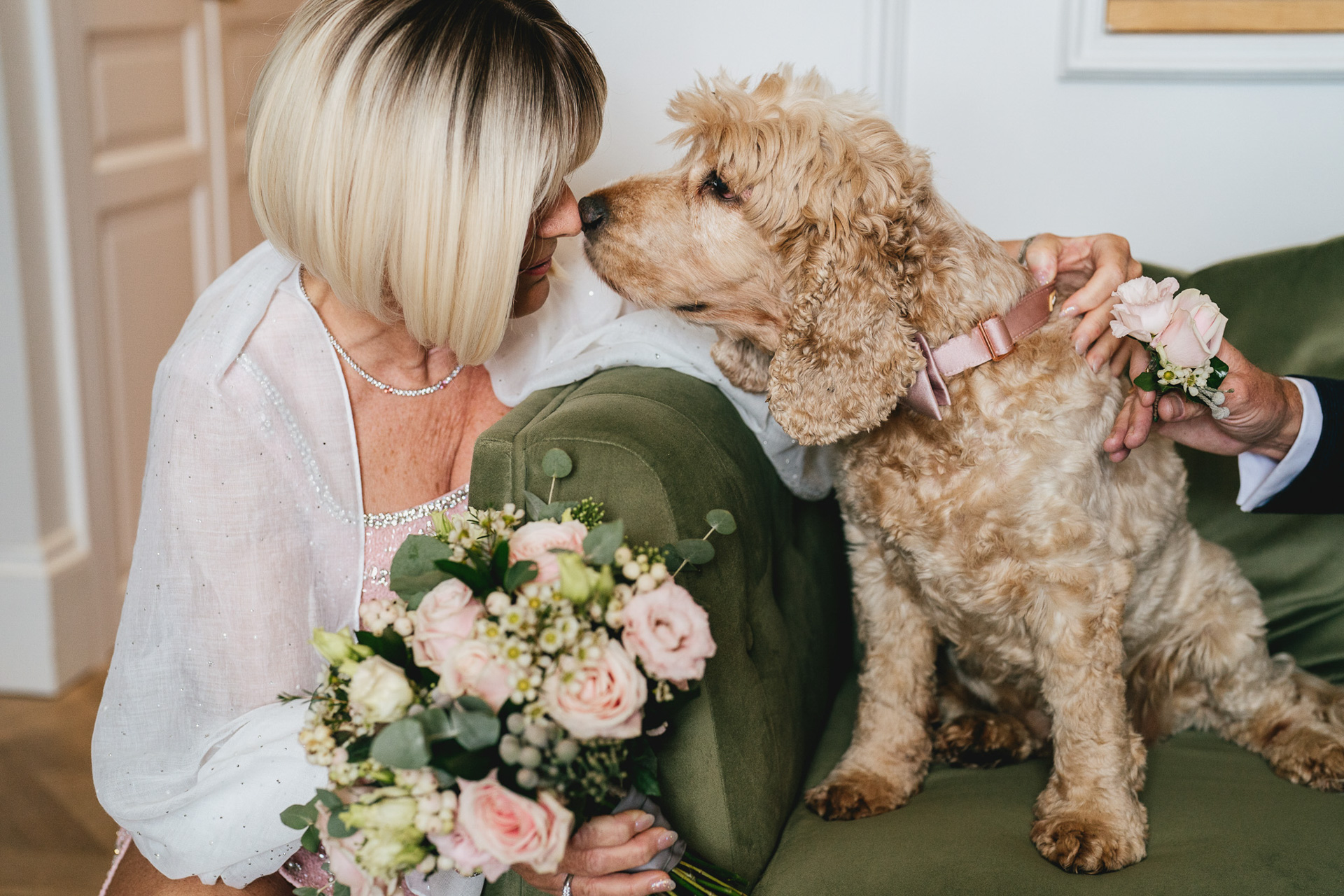 A bride touching noses with a dog on her wedding day at Lympstone Manor in Devon