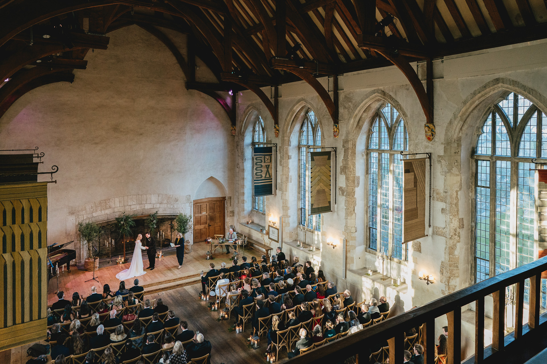 A wide shot of a wedding ceremony in the Great Hall at Dartington in Devon