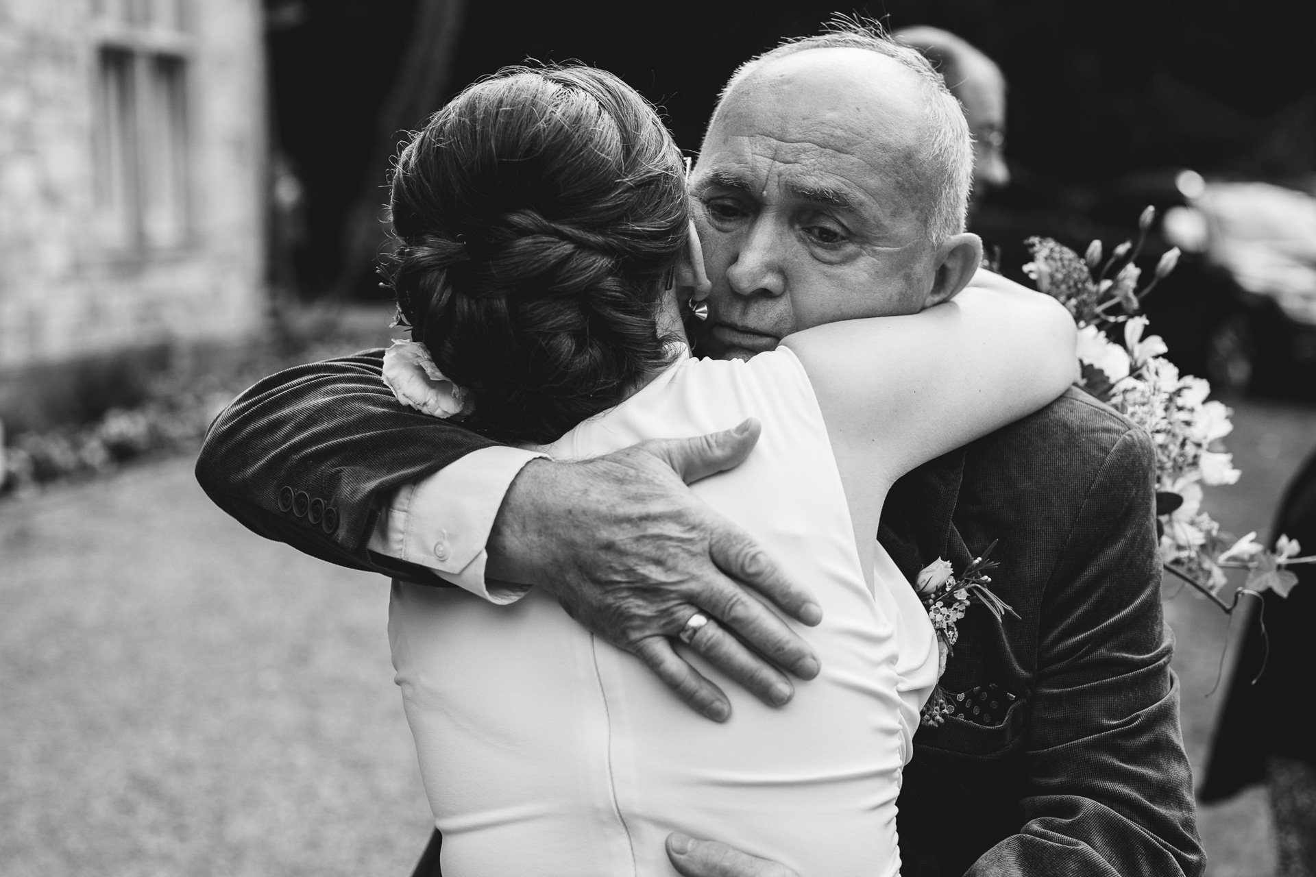 A father emotionally hugging his daughter after her wedding ceremony in Exeter